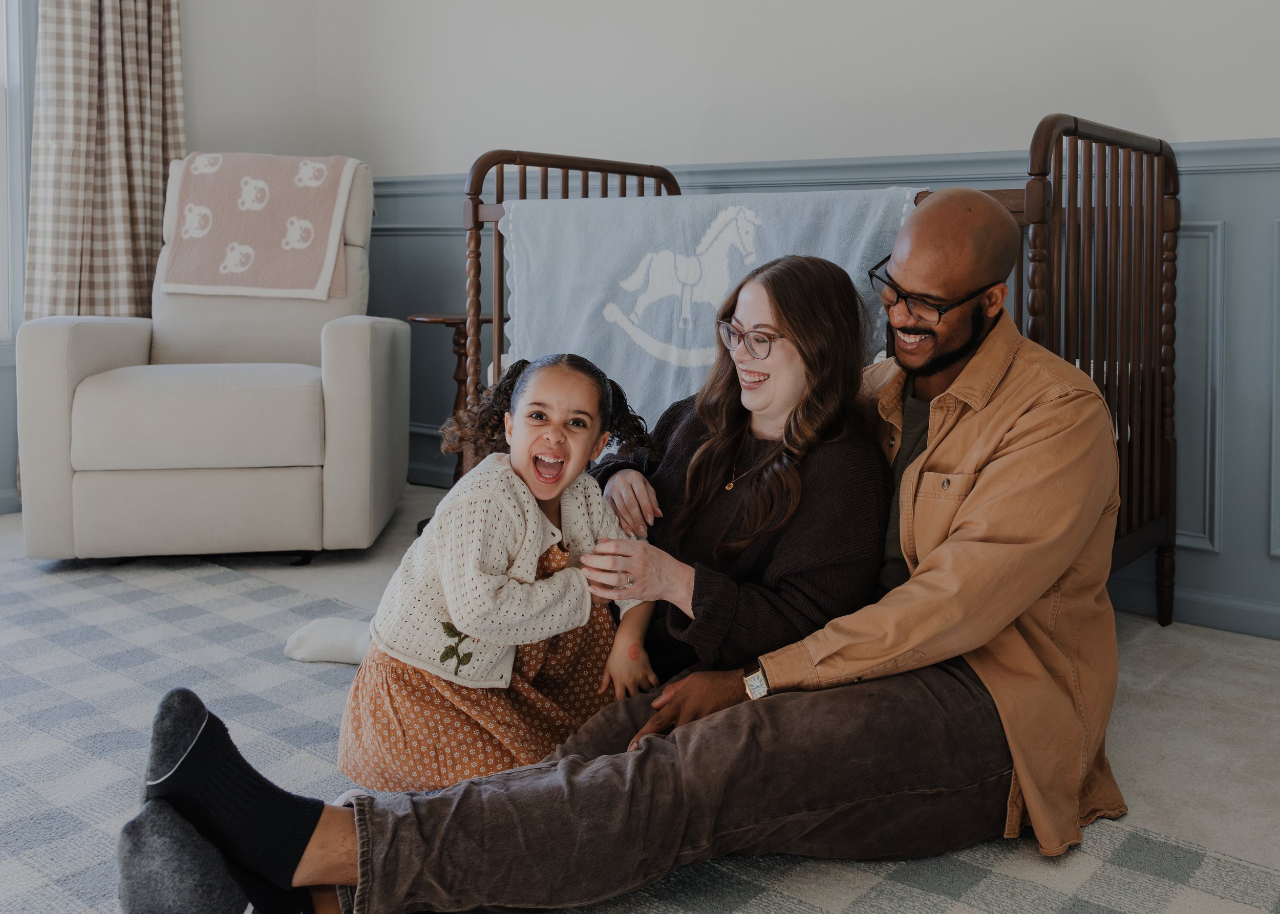 Family with 3 year old girl play in new baby's nursery during a maternity photo session at their home in Wake Forest, NC.