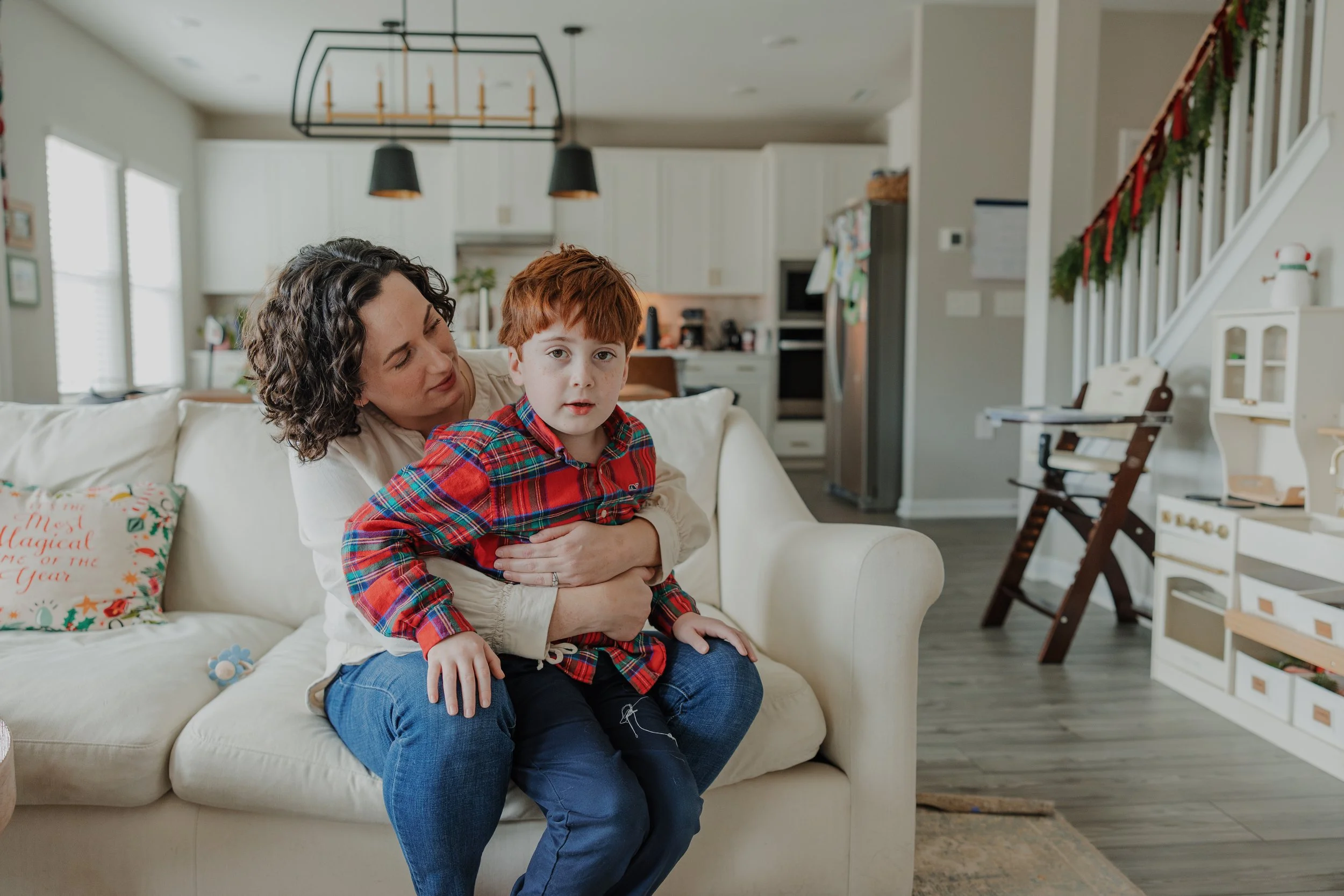 Mom hugs and calms overstimulated 6-year-old son during a family photo session captured at home in Raleigh.
