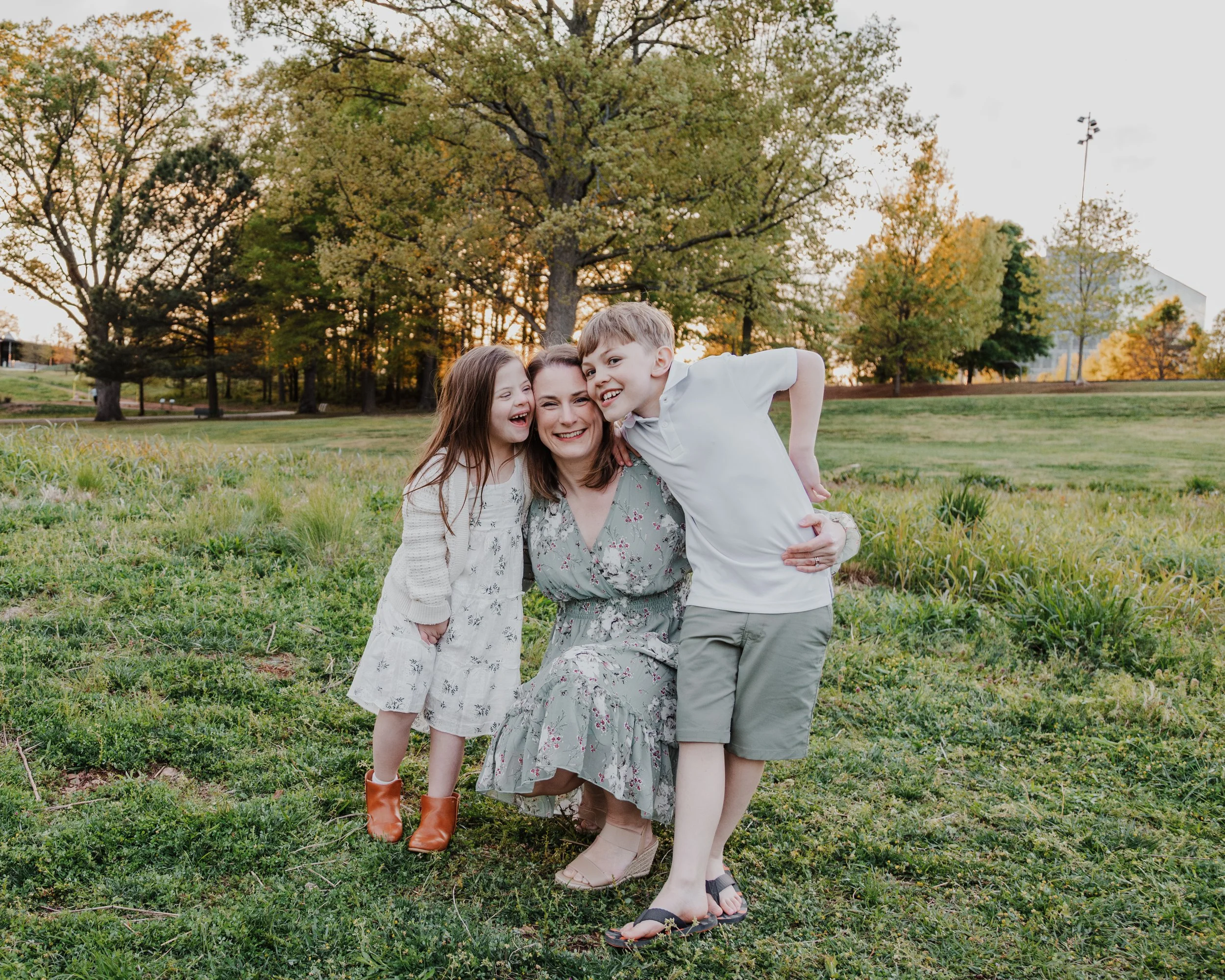 Mom poses with daughter, who has down syndrome, and 9-year-old son during a spring mini photo session at the North Carolina Museum of Art Park.