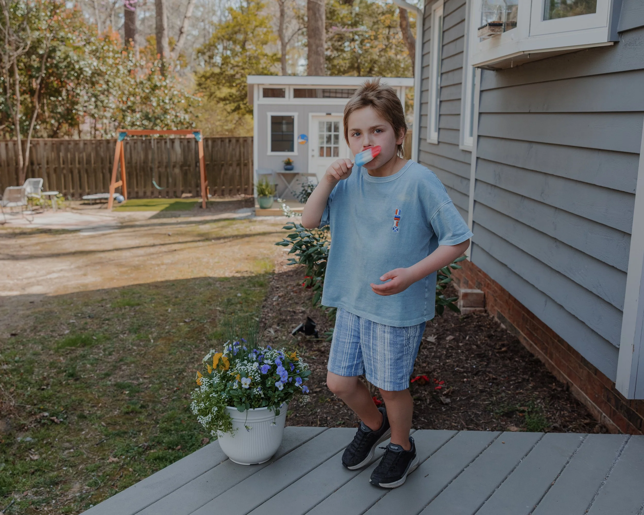 Autistic child enjoying a popsicle outside his Make-A-Wish recording studio during a neurodivergent-friendly family photography session in Durham, NC.