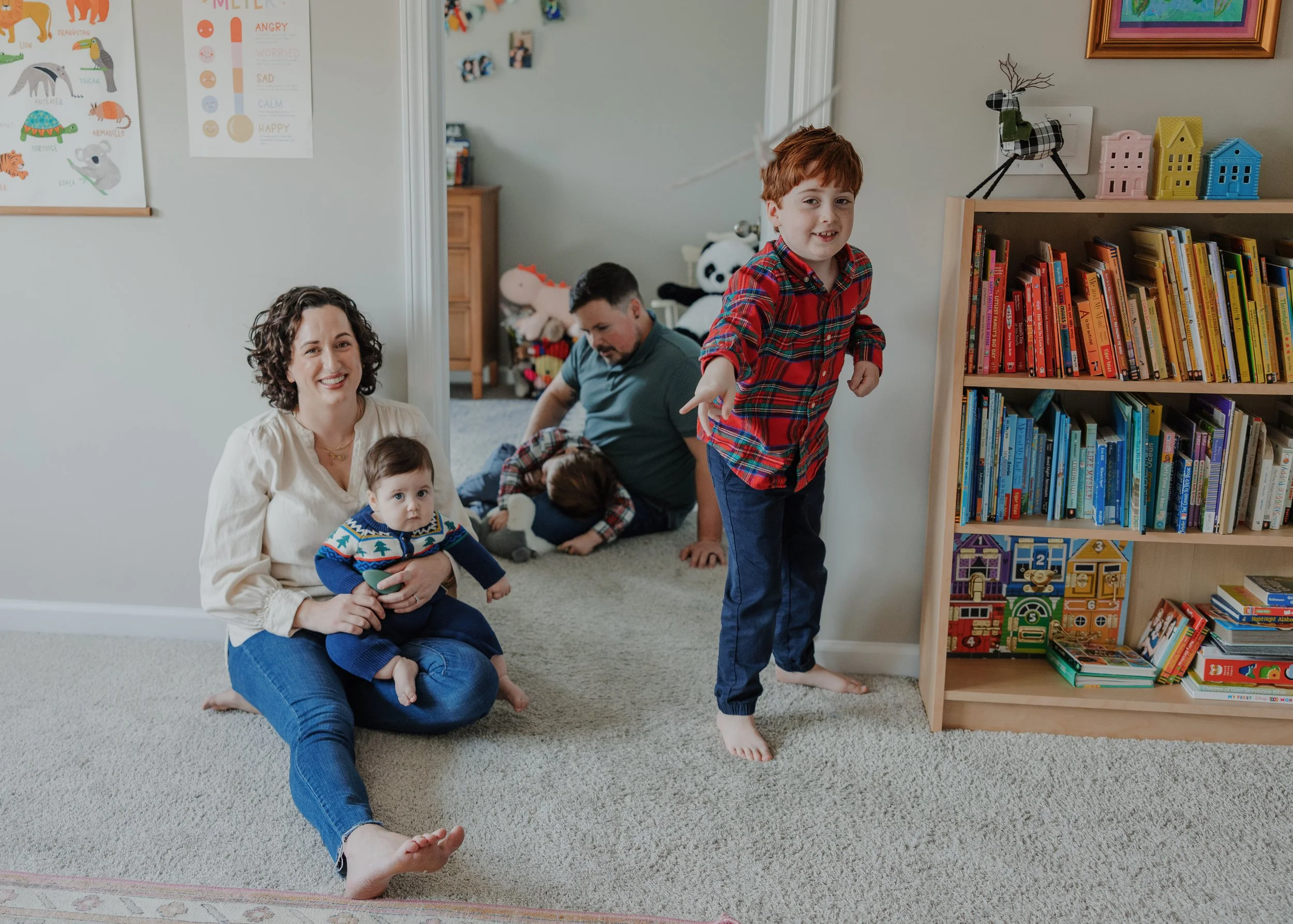 Parents spending time with their three young children during a relaxed, full-length in-home family photography session in Raleigh, NC.