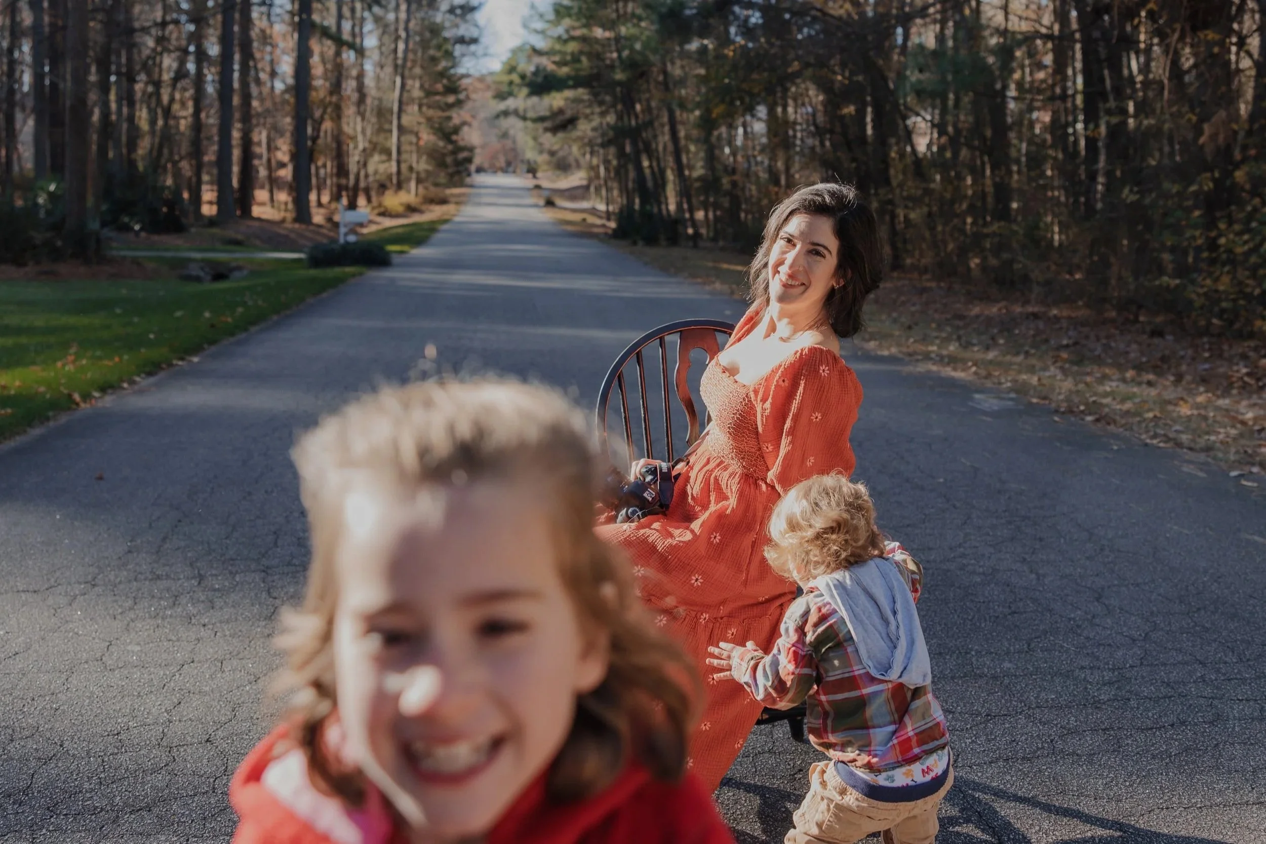 Raleigh family photographer poses for branding photos while her kids run around her.