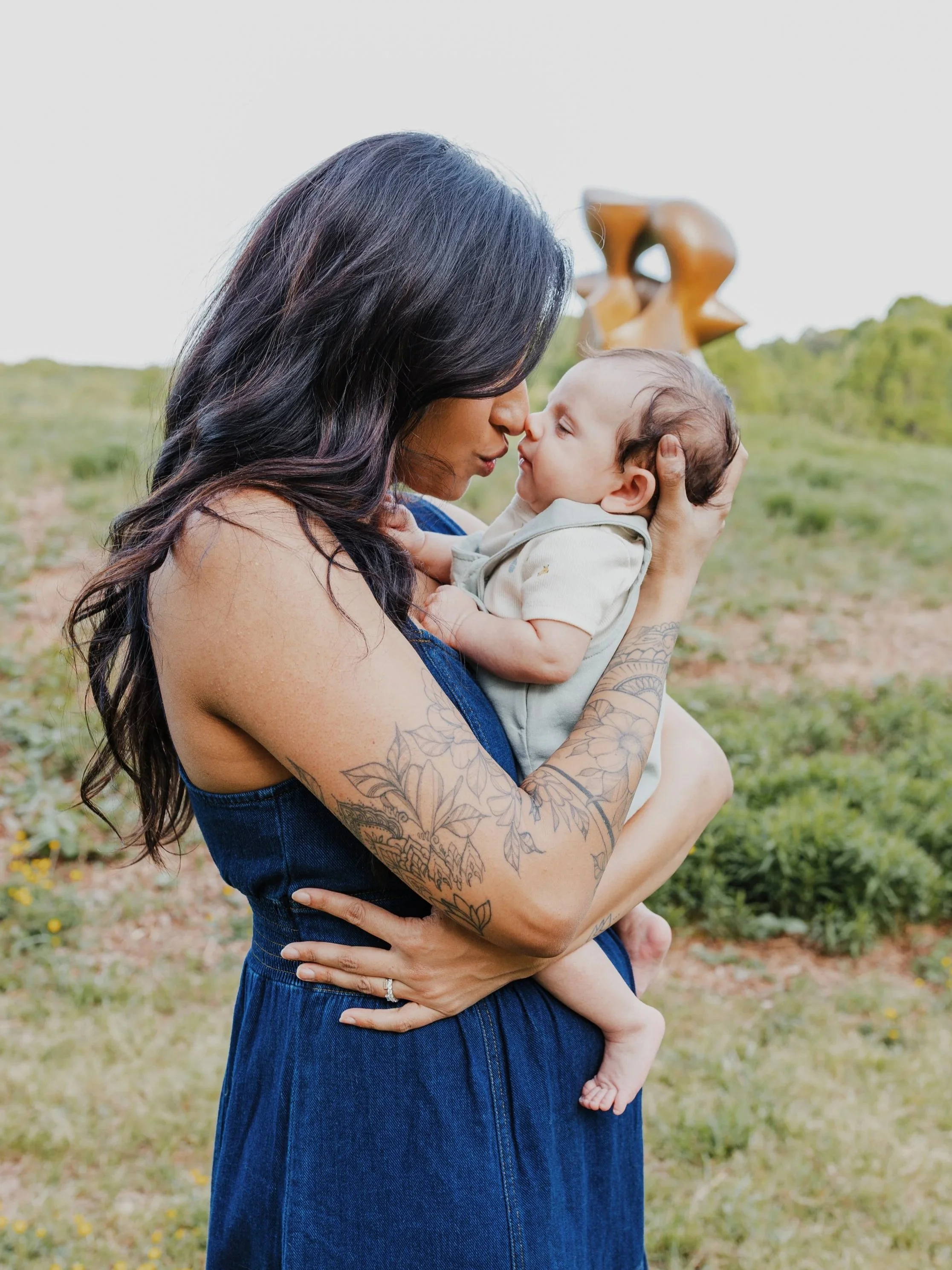 Mom holds baby nose-to-nose during a newborn photoshoot at the North Carolina Museum of Art in Raleigh.