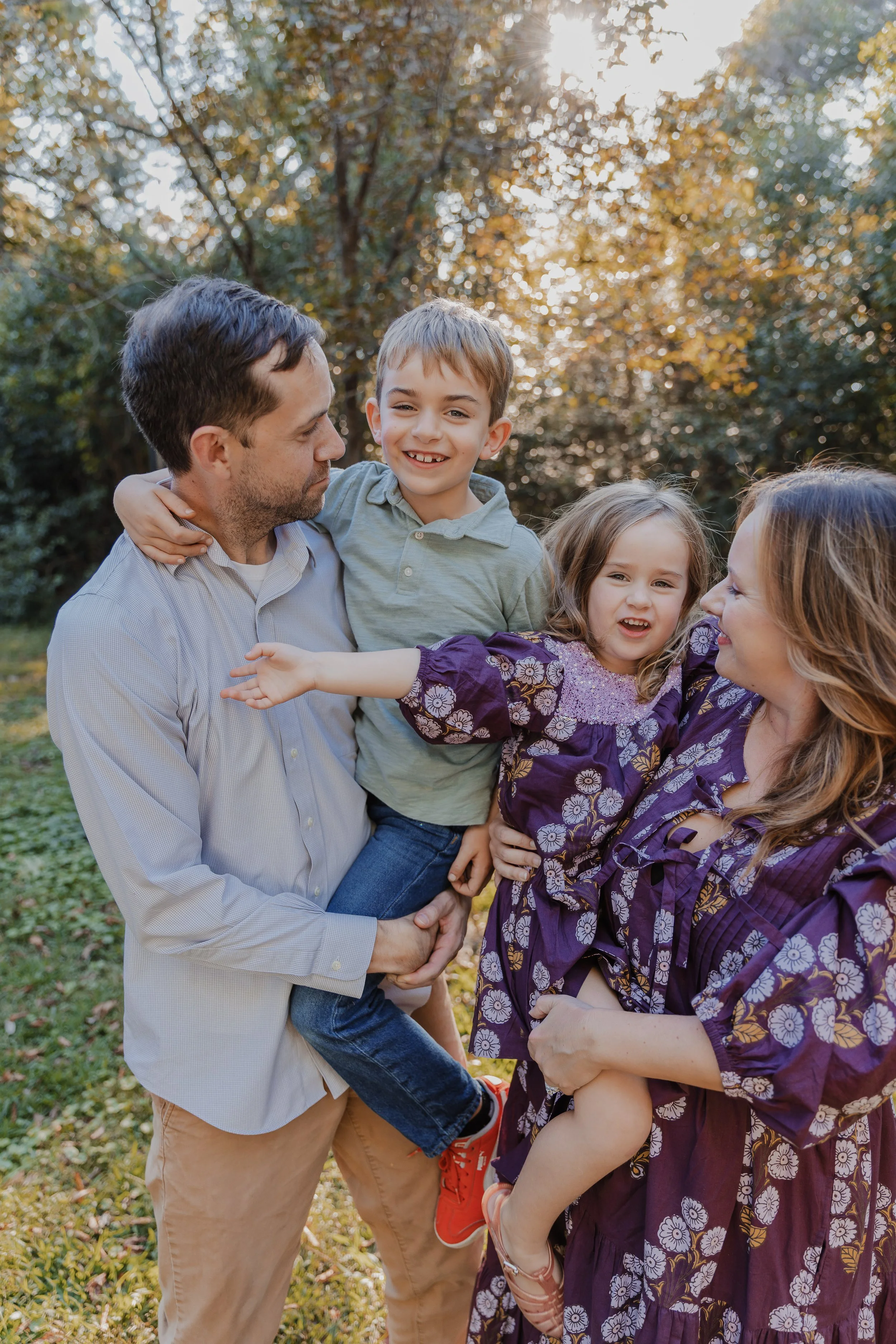 Family with two young kids pose for a fall family mini photo session at Historic Oak View County Park in Raleigh, NC.