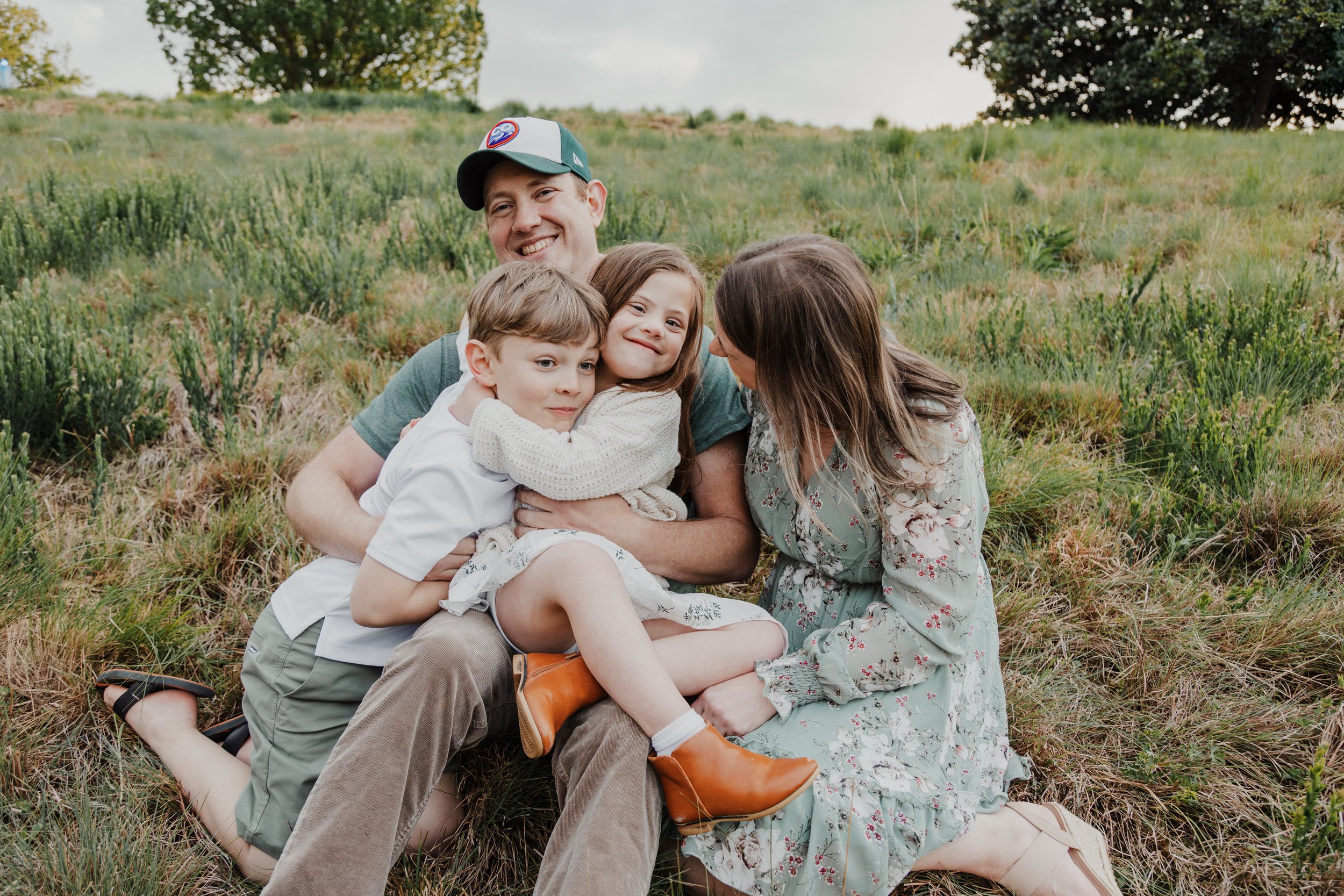 Family poses with 9-year-old son and 7-year-old daughter with Down Syndrome for spring family photos at the North Carolina Museum of Art Park in Raleigh.
