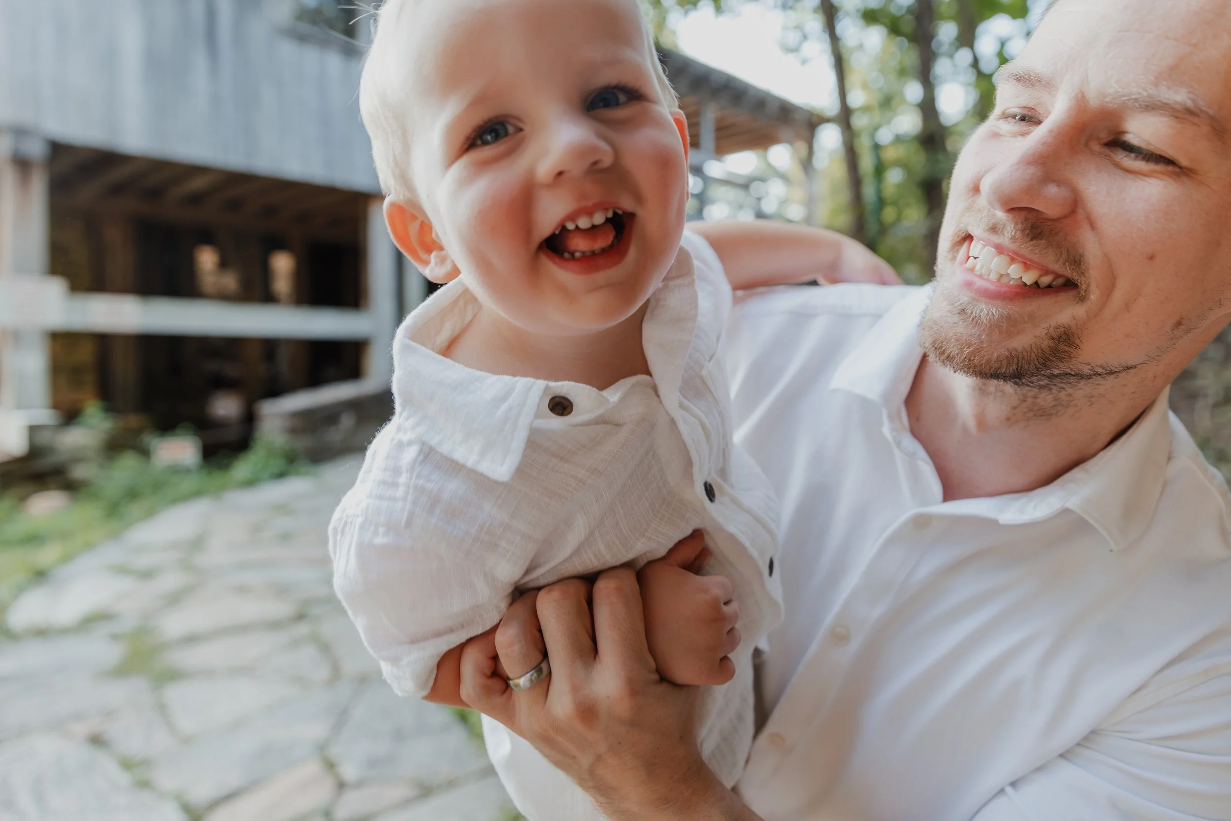 Two-year-old boy laughs into the camera during a movement-focused maternity session at Yates Mill County Park in Raleigh, NC.