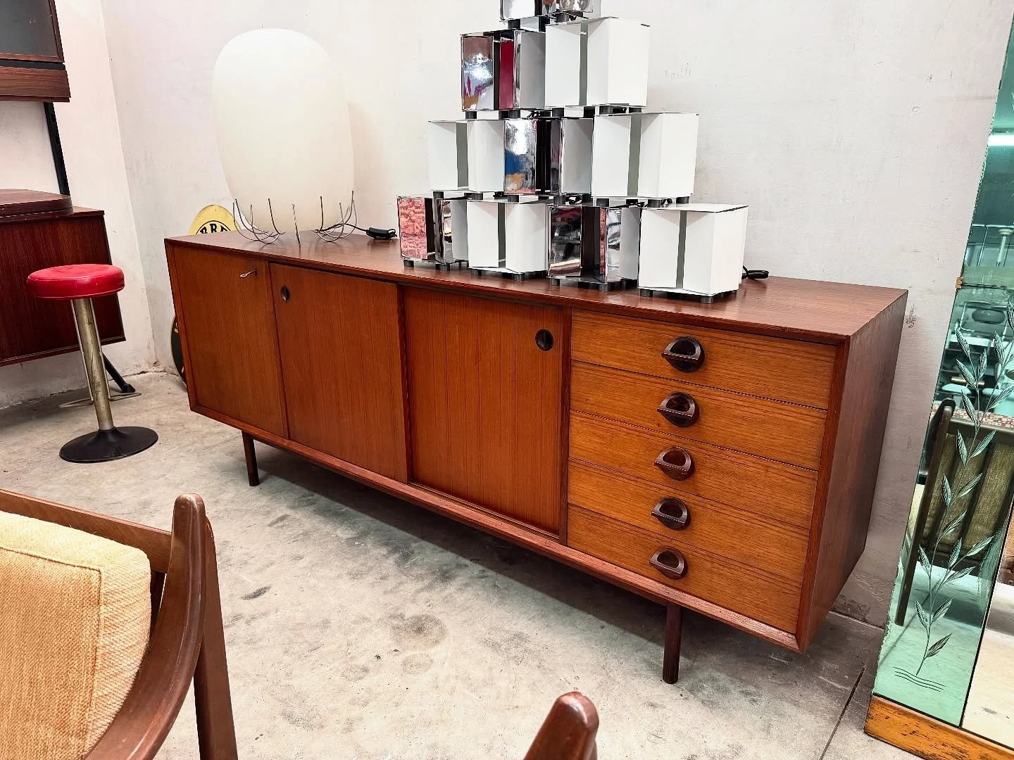 DISPONIBILE 🟢
Mobile credenza in stile Scandivano, anni' 60.
Struttura in teak con maniglie a mezzaluna sui cinque cassetti, dei quali il primo con portaposate rivestito in feltro verde d'epoca, due ante scorrevoli ed una terza dotata di serratura c