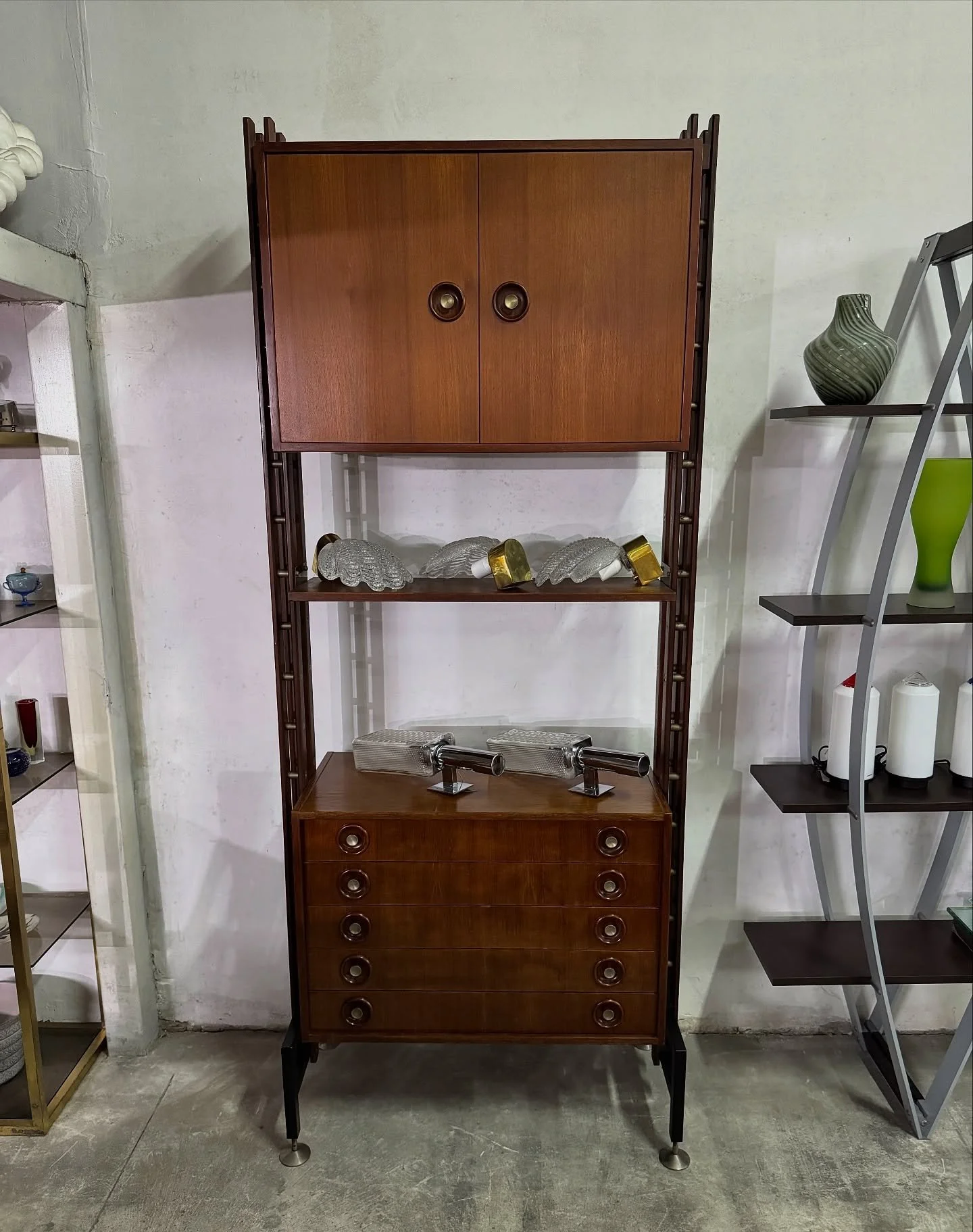 DISPONIBILE 🟢
Elegante libreria modulare autoportante realizzata in Italia negli anni &rsquo;50.
La struttura &egrave; caratterizzata da montanti verticali in legno scuro con elementi metallici di fissaggio e piedini regolabili, che conferiscono sta