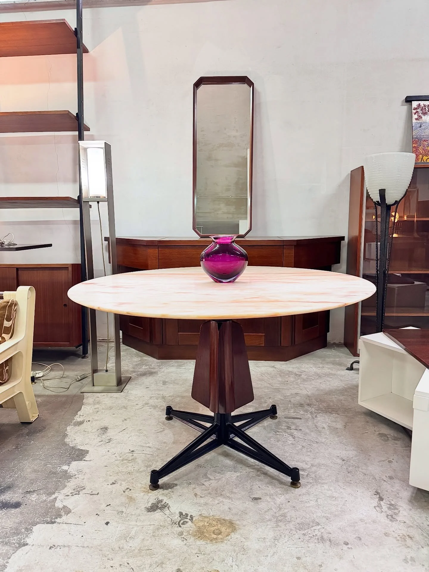 DISPONIBILE 🟢

Tavolo da pranzo con piano in marmo Rosa di Portogallo di forte spessore, anni '60.
La base &egrave; composta da una struttura centrale in metallo verniciato nero con piedi a stella, arricchita da un elemento sagomato in legno che avv