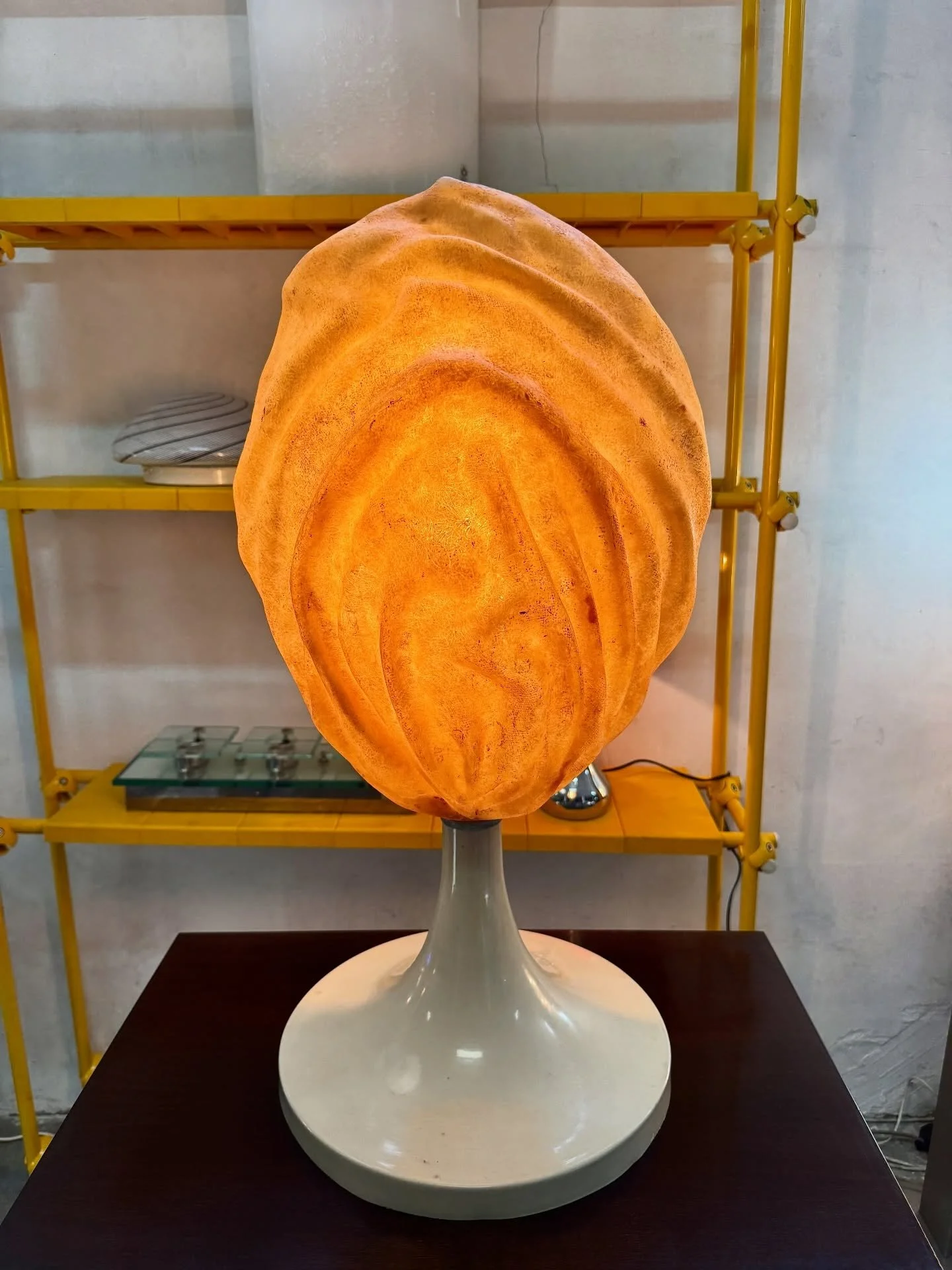 DISPONIBILE 🟢

Lampada da tavolo scultorea in vetroresina, anni &rsquo;70.
Caratterizzata da un grande diffusore organico in vetroresina modellata, con superficie materica e ondulata che ricorda una forma naturale.
La luce filtra attraverso il mater