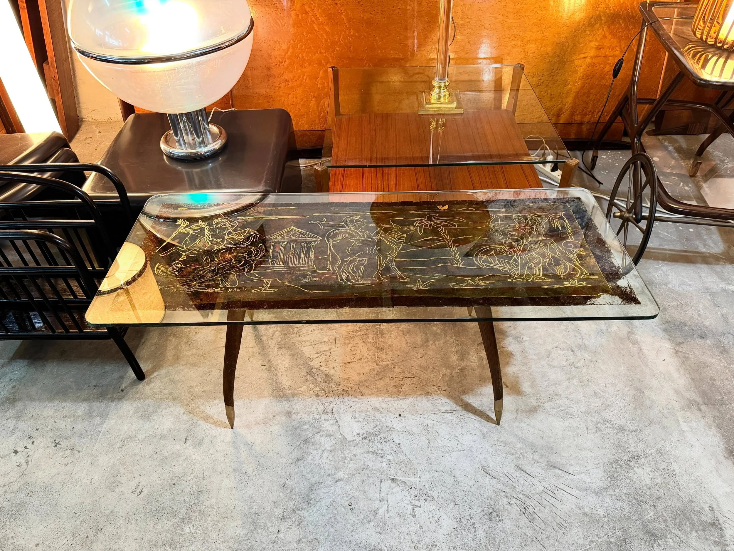 DISPONIBILE - emporium900.com 🟢

Tavolino da salotto con pannello decorato firmato Haeti, anni &rsquo;50.

Tavolino rettangolare con piano in vetro molato e struttura in legno con puntali in ottone. Al centro, pannello artistico firmato Haeti con sc
