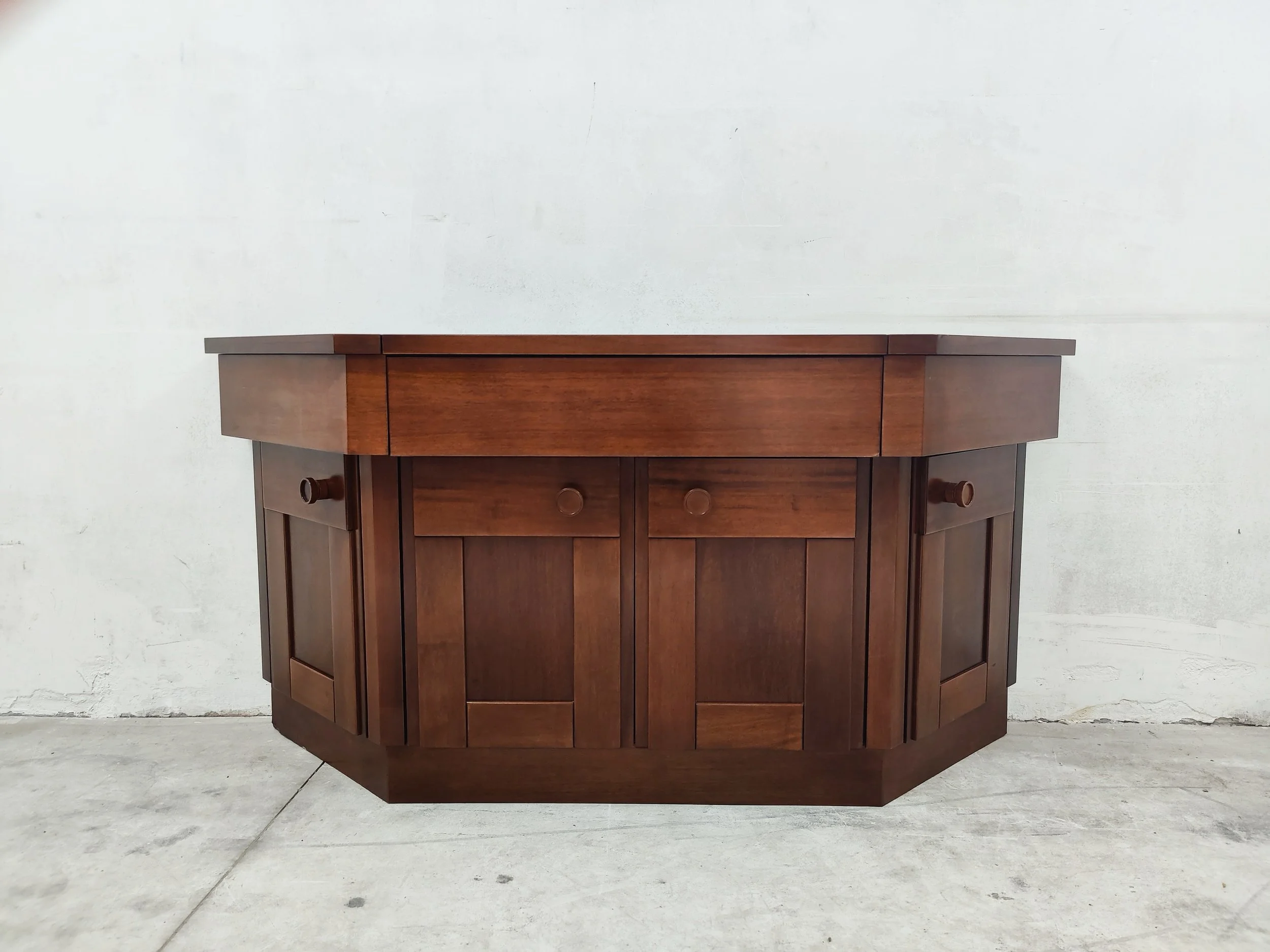 DISPONIBILE - emporium900.com 🟢

Credenza bar in legno di Silvio Coppola per Bernini, anni &rsquo;60.

Struttura ottagonale in legno di noce, con due ante ed un cassetto centralmente, due ante e due contenitori laterali a pannelli geometrici su tutt