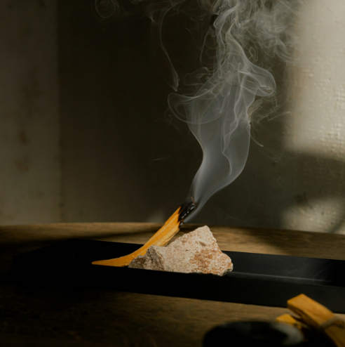 Smoke rising from incense resting on a stone