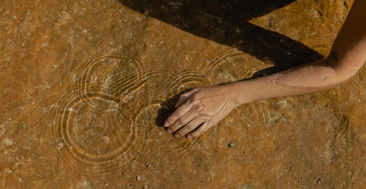 A hand resting on warm sand