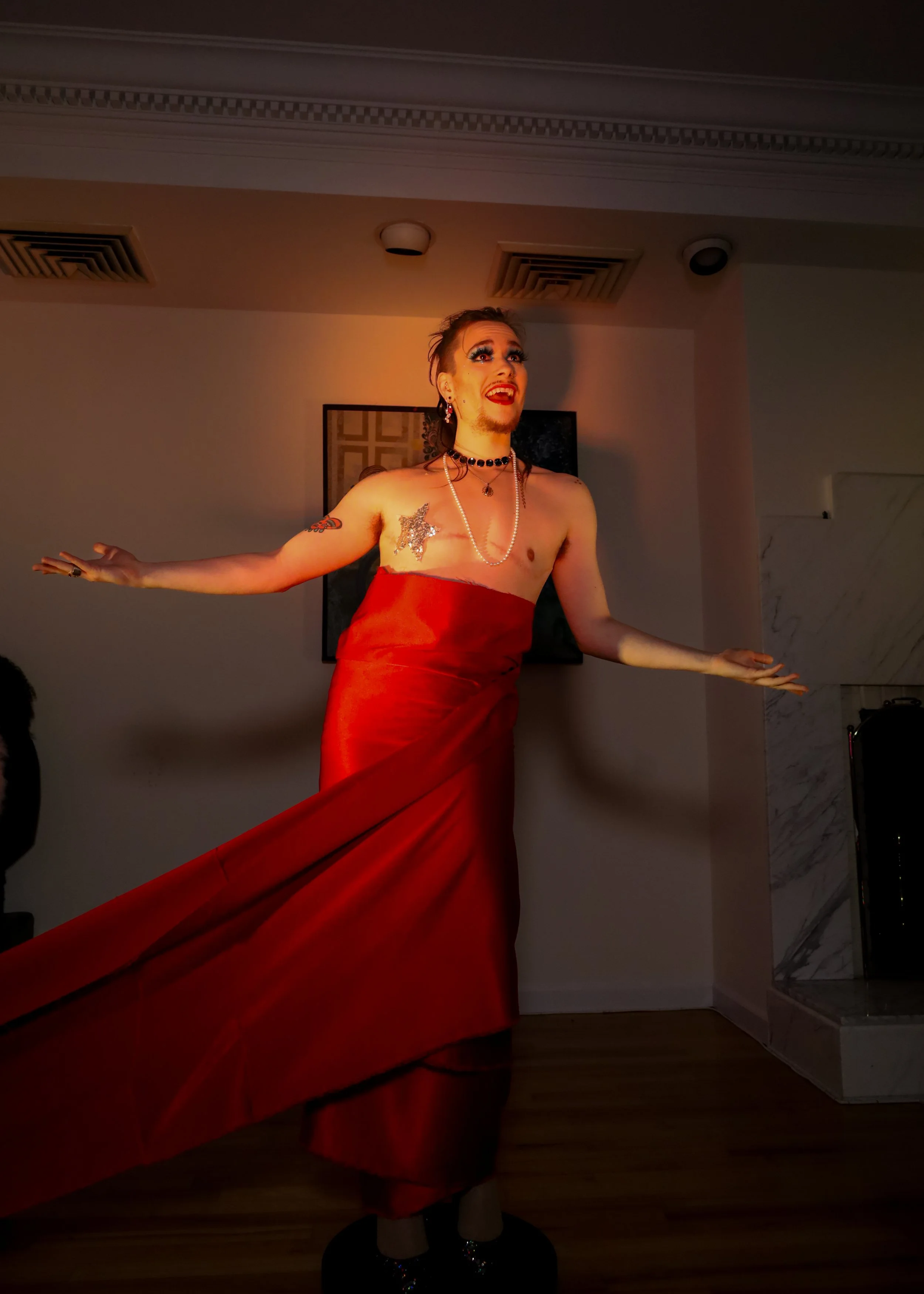 Maqks with red fabric in drag with one golden star pasty