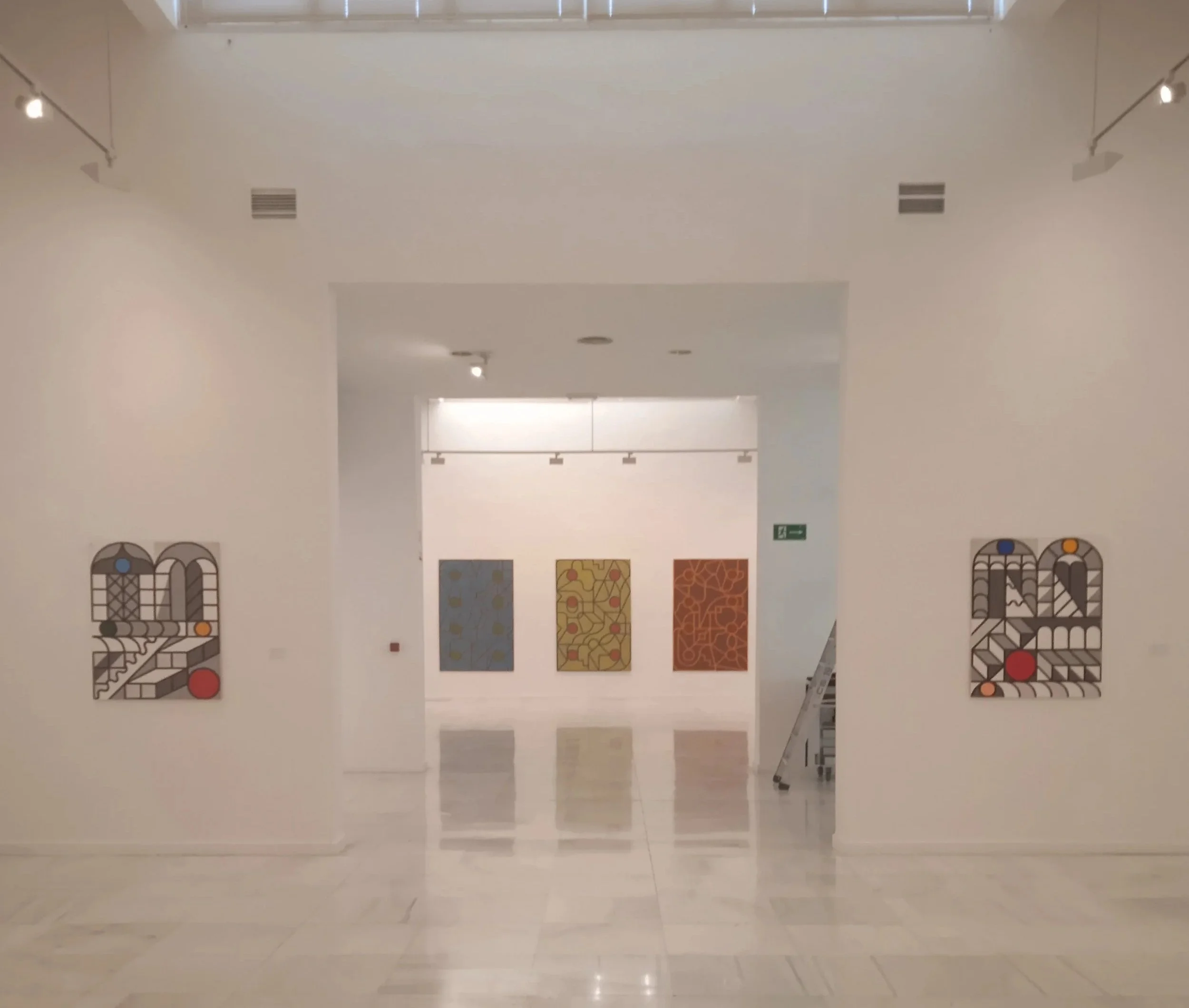 Galería de arte con pinturas abstractas en paredes blancas, reflejadas en el piso de mármol