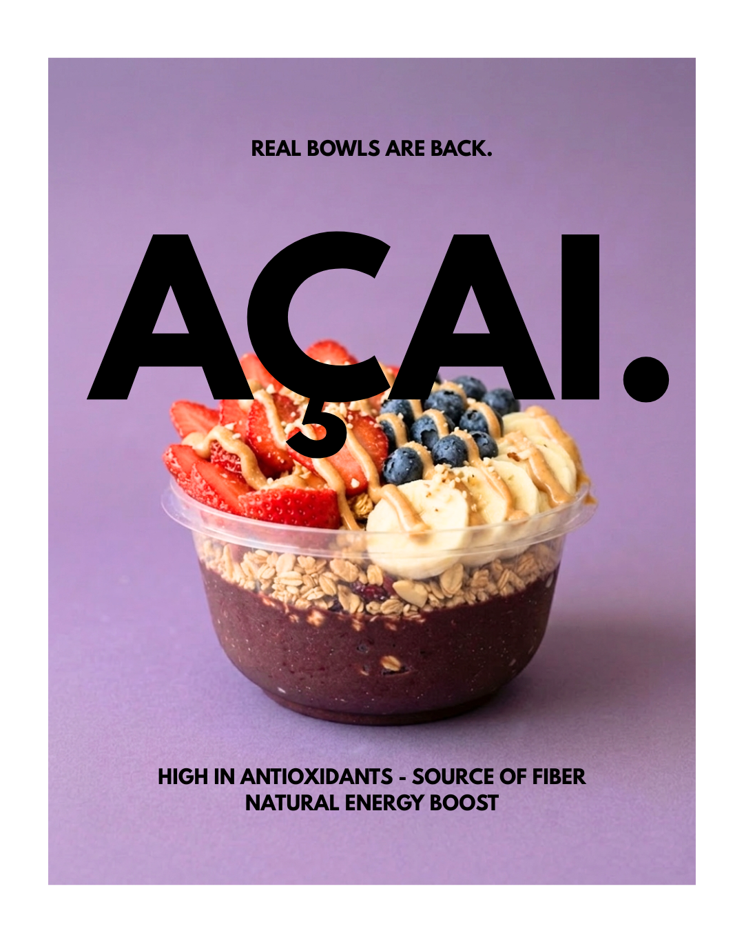 A healthy acai bowl topped with strawberries, blueberries, banana slices, granola, and drizzled with nut butter against a purple background.