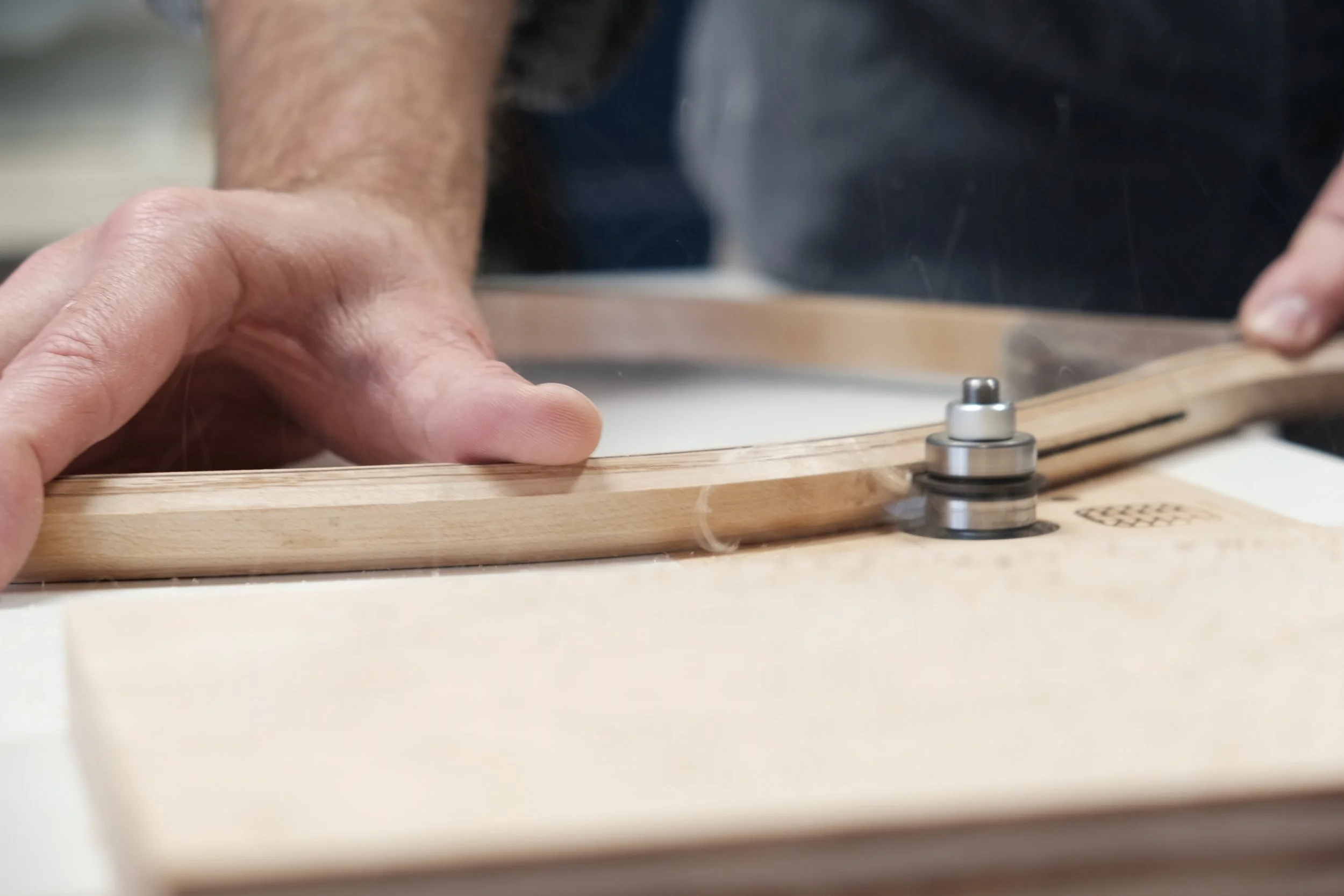 A person using a router to cut in channel on side of fishing net frames.