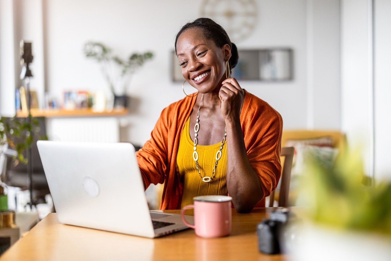 smiling woman looking at her laptop