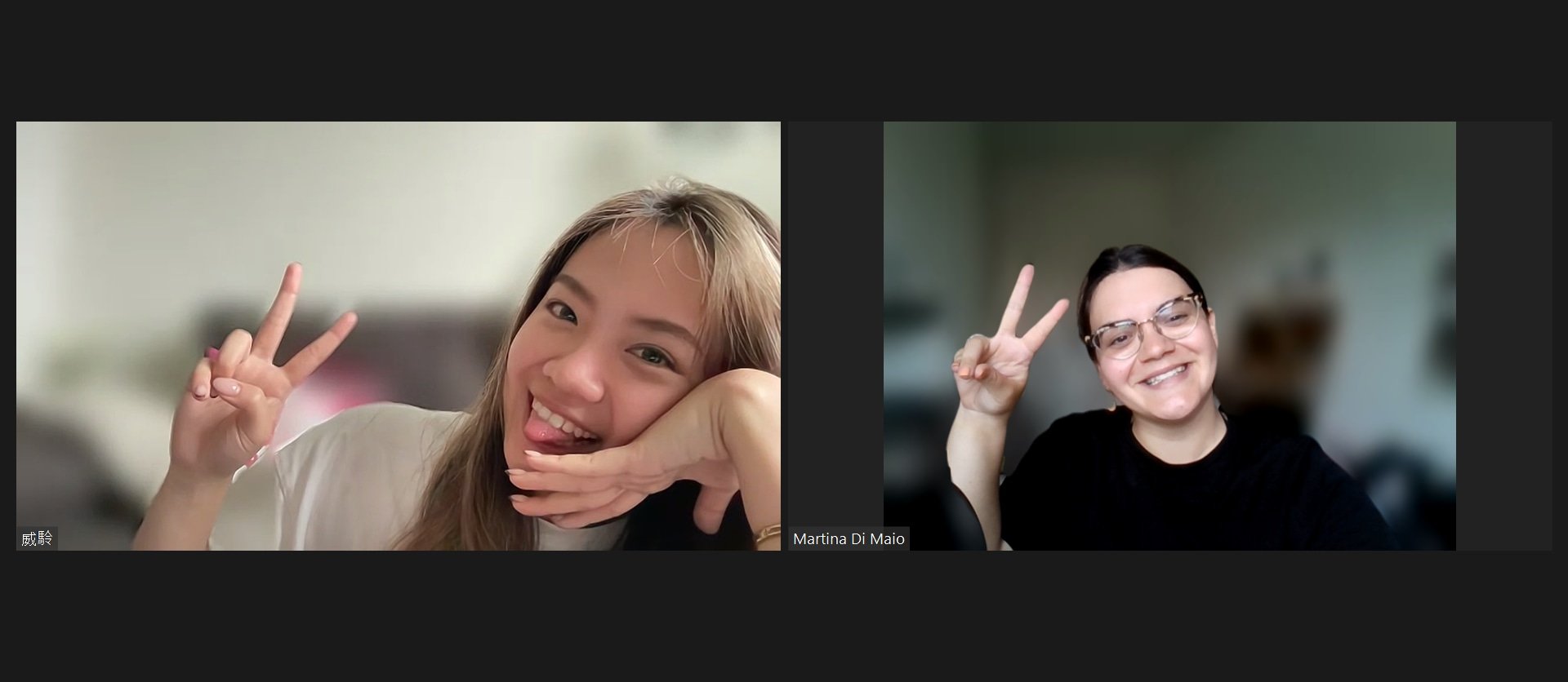 Two women smiling and making peace signs during a video call.