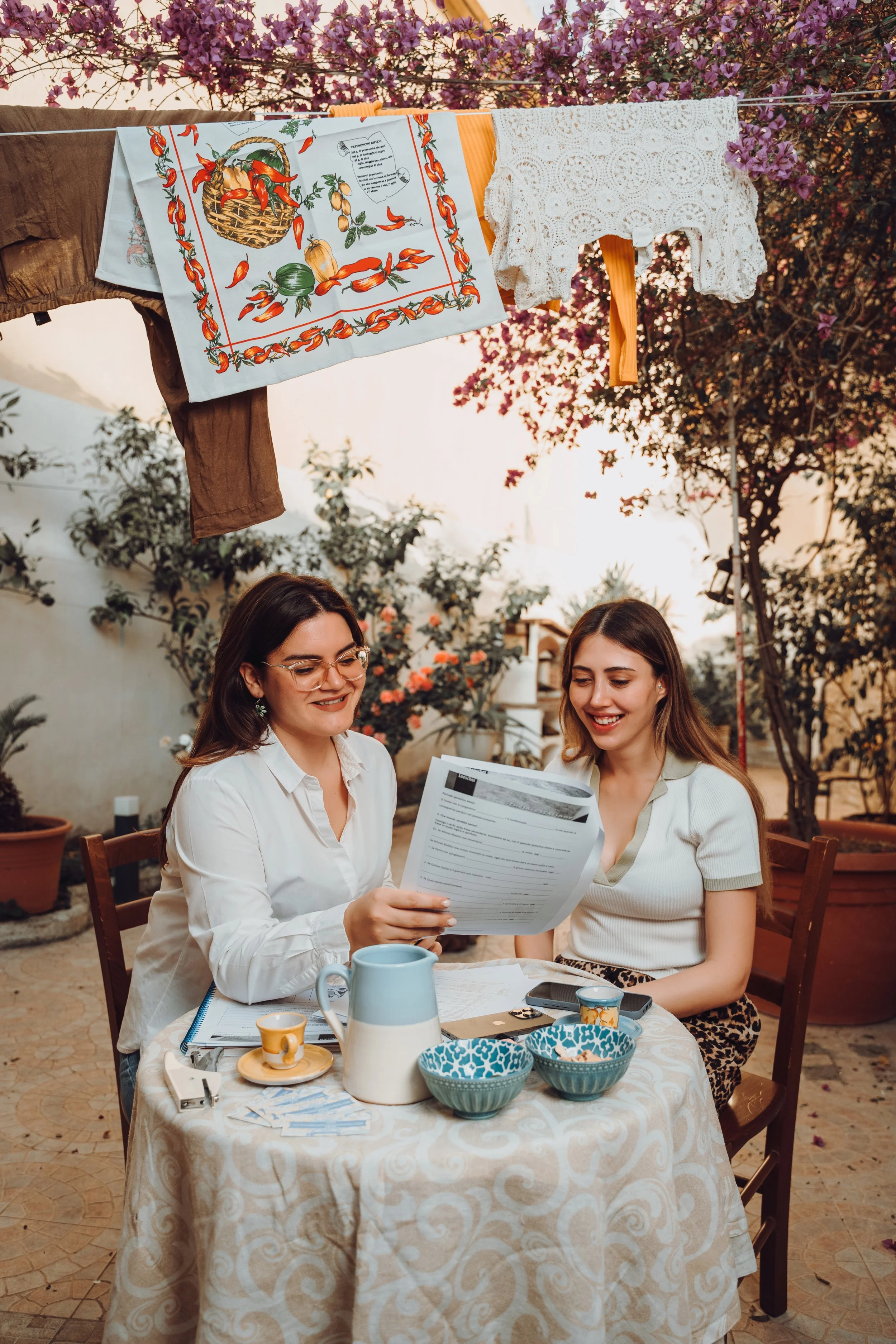 two women sitting in a garden speaking italian