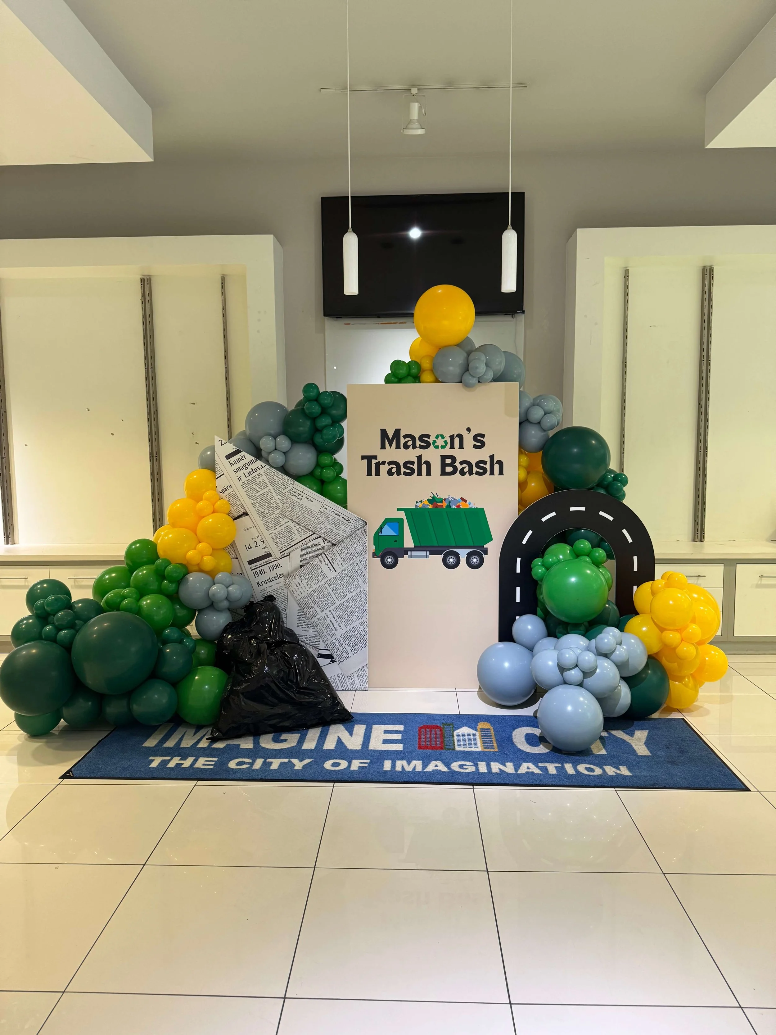 Garbage truck themed balloon arrangement and backdrop for a kid’s birthday party at Imagine City in the Valencia Town Center in Santa Clarita.