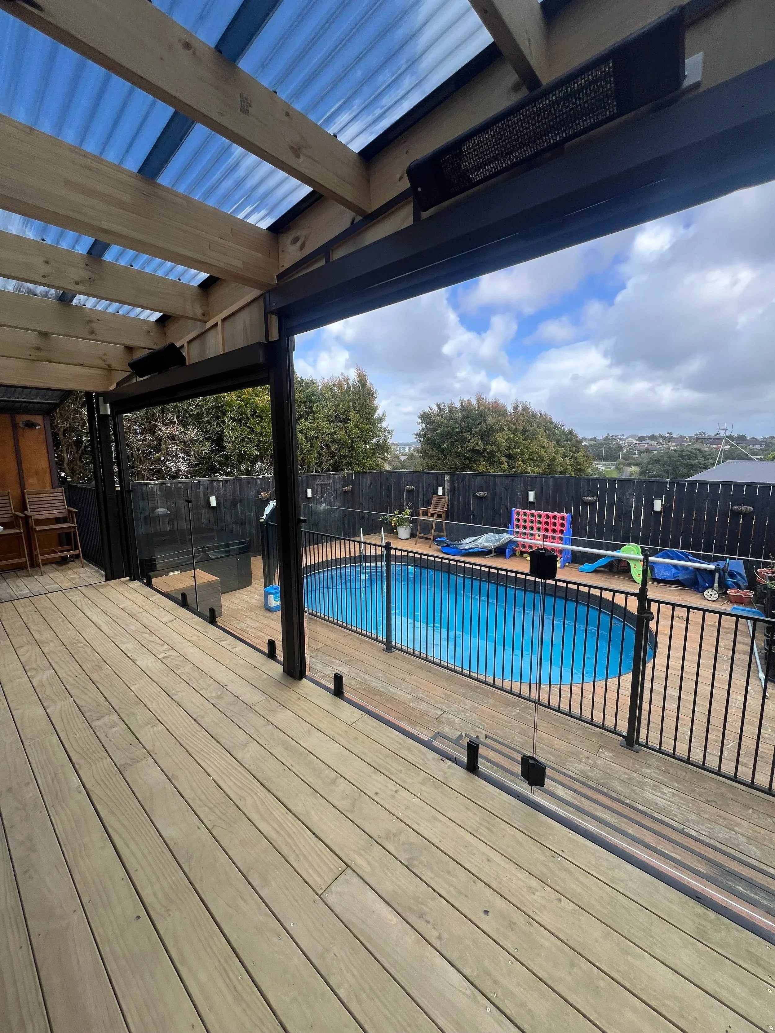 Black aluminium pool fence on a covered timber deck, Auckland