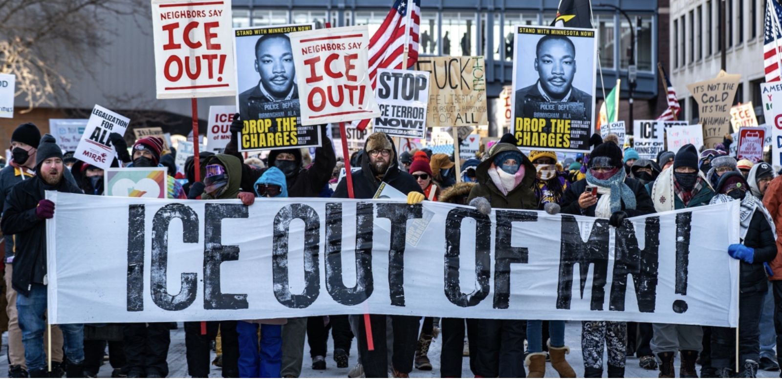 Protesters holding "ICE OUT OF MN" sign