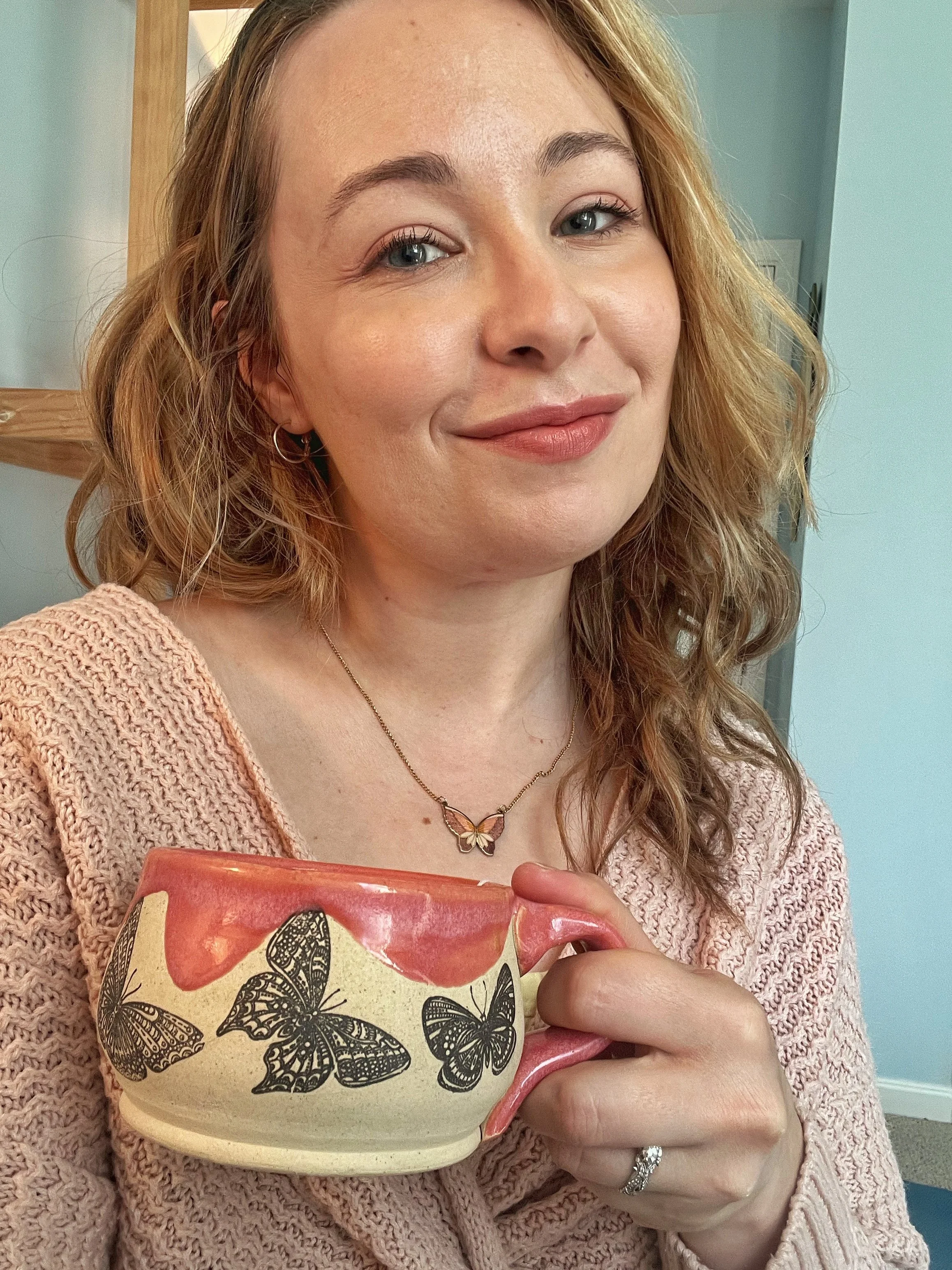 Owner Desi Gilliland holding a mug with butterflies on it