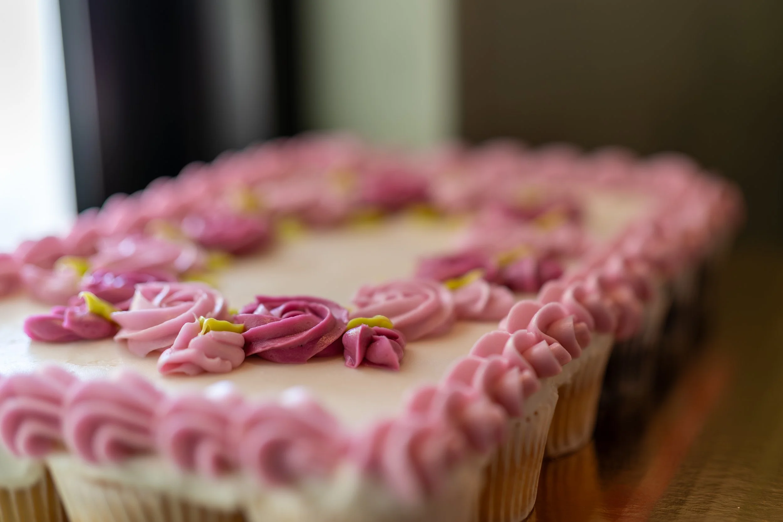 Rectangular cake decorated with pink icing flowers and borders.