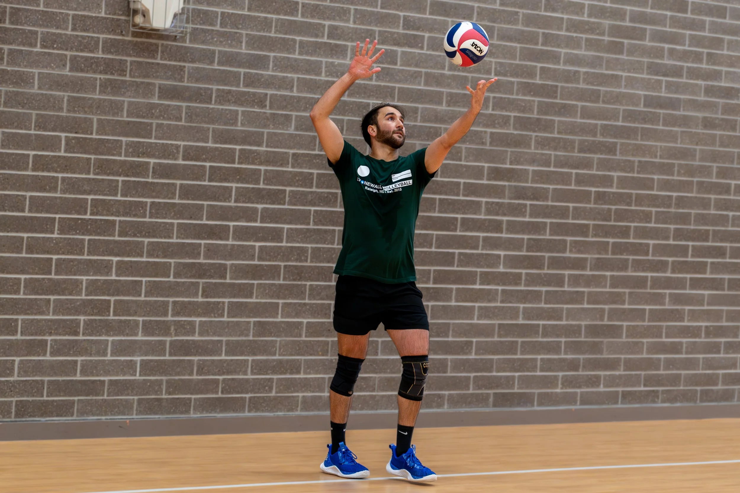 Volleyball player preparing to serve indoors
