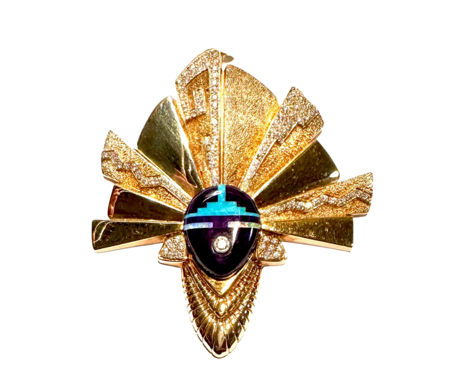 A gold-colored, ornate decorative piece resembling a stylized animal head with fan-like ears and a central face, featuring geometric patterns and vibrant colors.