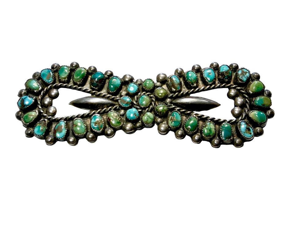 A vintage brooch with turquoise and green stones and silver detailing, shaped like a butterfly.