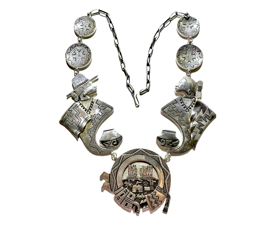 Silver necklace with tribal-style pendants, including two animal heads and a circular medallion with a detailed scene.
