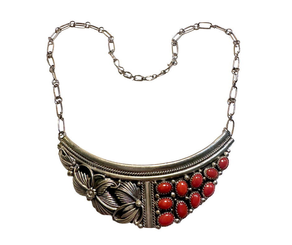 Silver necklace with butterfly and floral design, adorned with red oval stones.