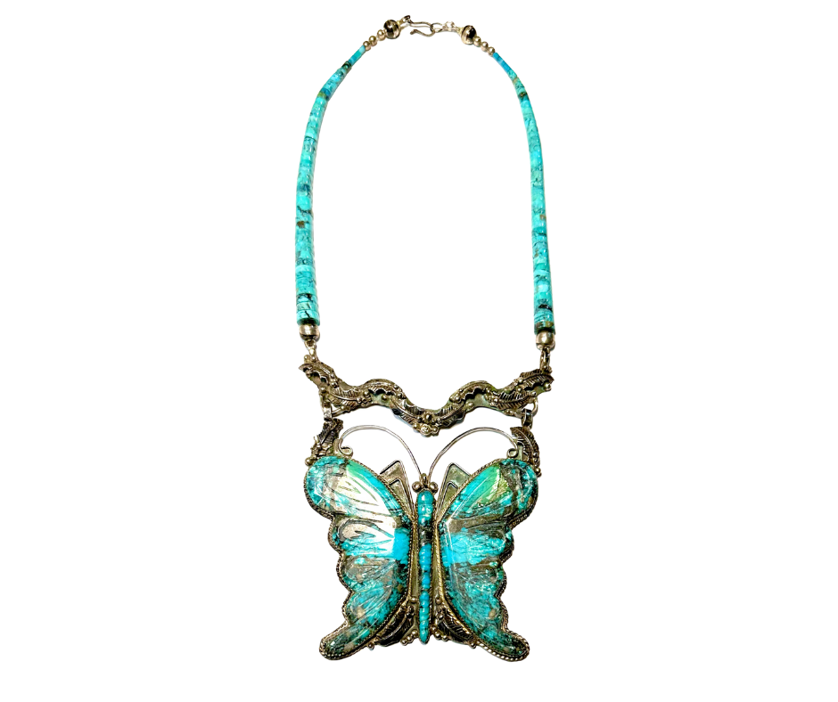 A necklace with a large butterfly pendant featuring turquoise and silver details.