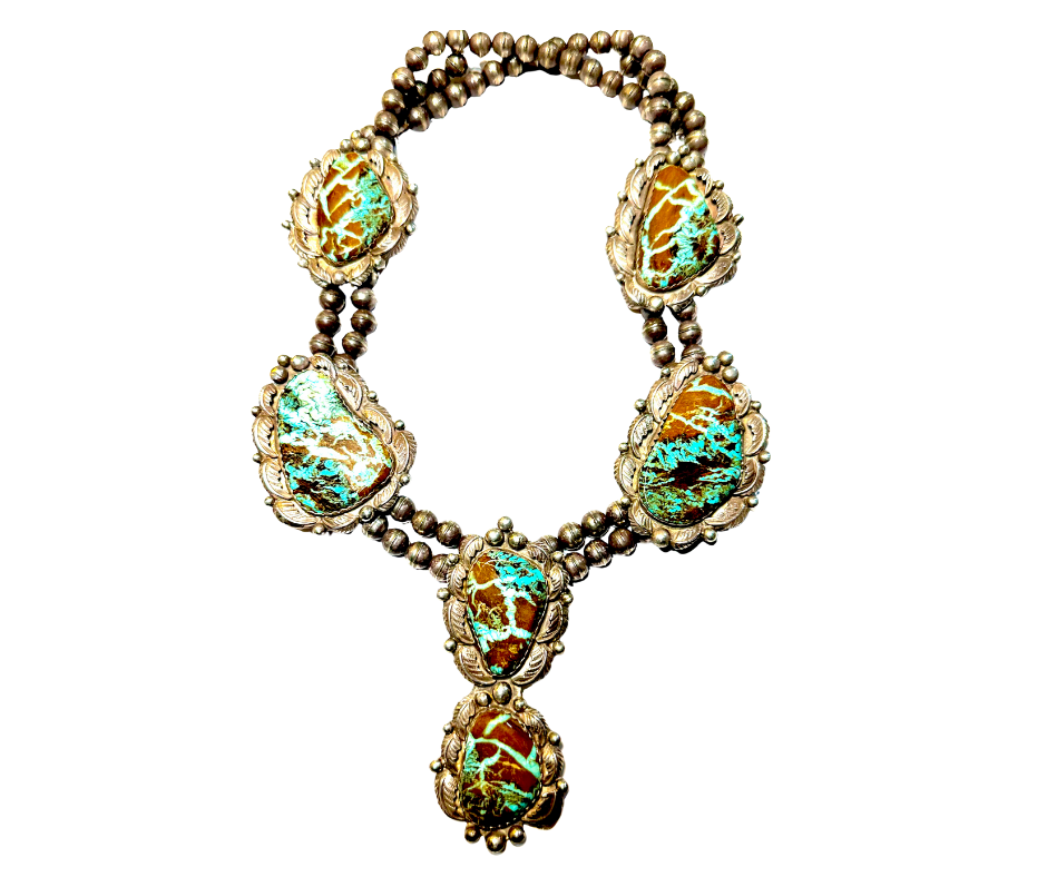 Silver necklace with large turquoise stones and intricate detailing on each stone, arranged in a symmetrical pattern.