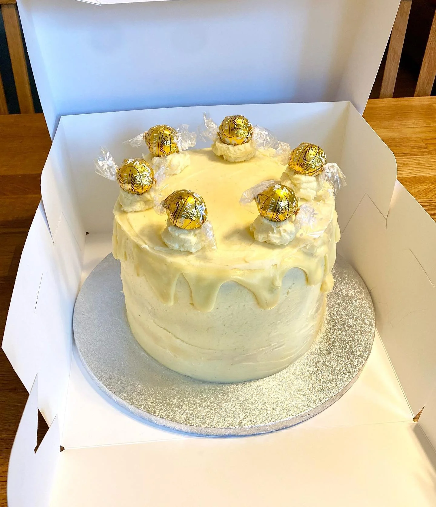White chocolate Lindt truffle cake 😍 Three layers of vanilla sponge sandwiched between and covered with white chocolate buttercream, dripped with white chocolate ganache and finished with white chocolate buttercream swirls, topped with golden snitch