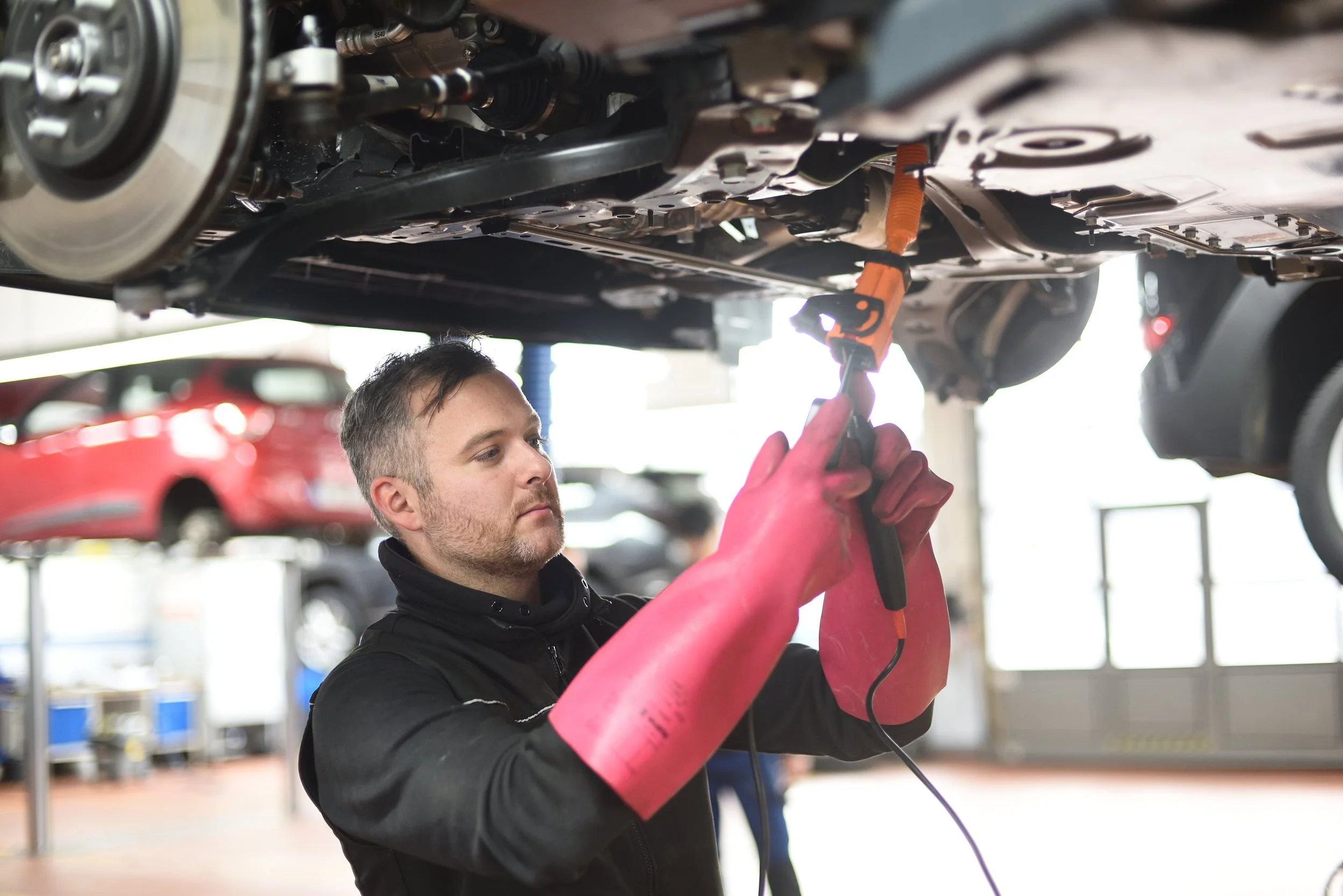 Mechaniker arbeitet an einer Hebebühne an einem Auto