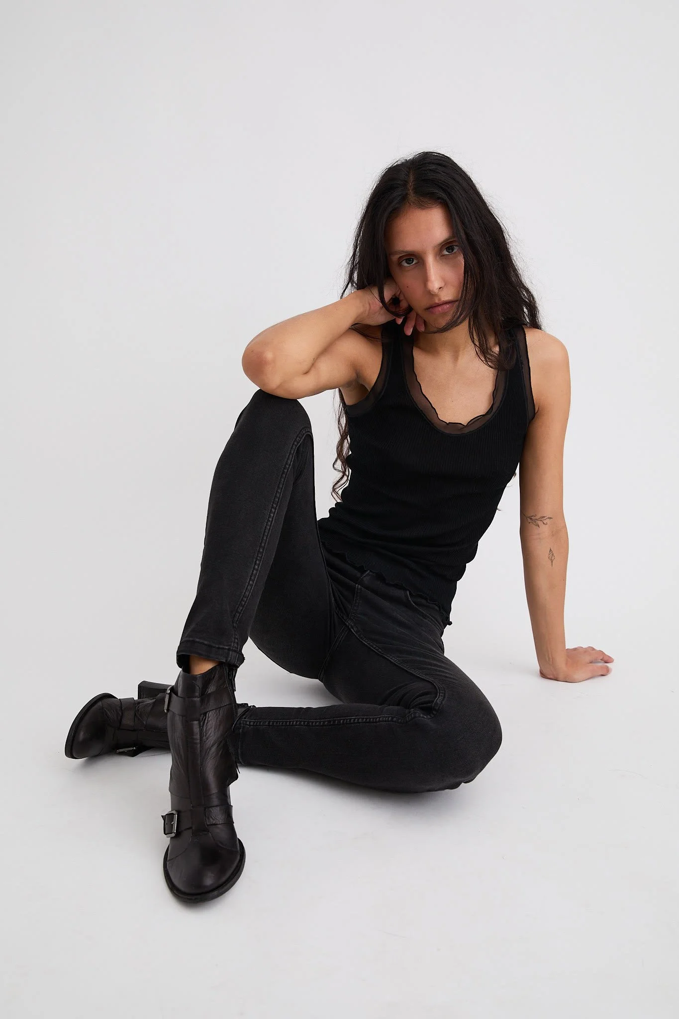 Polas mannequin en tenue noir assis sur fond blanc
