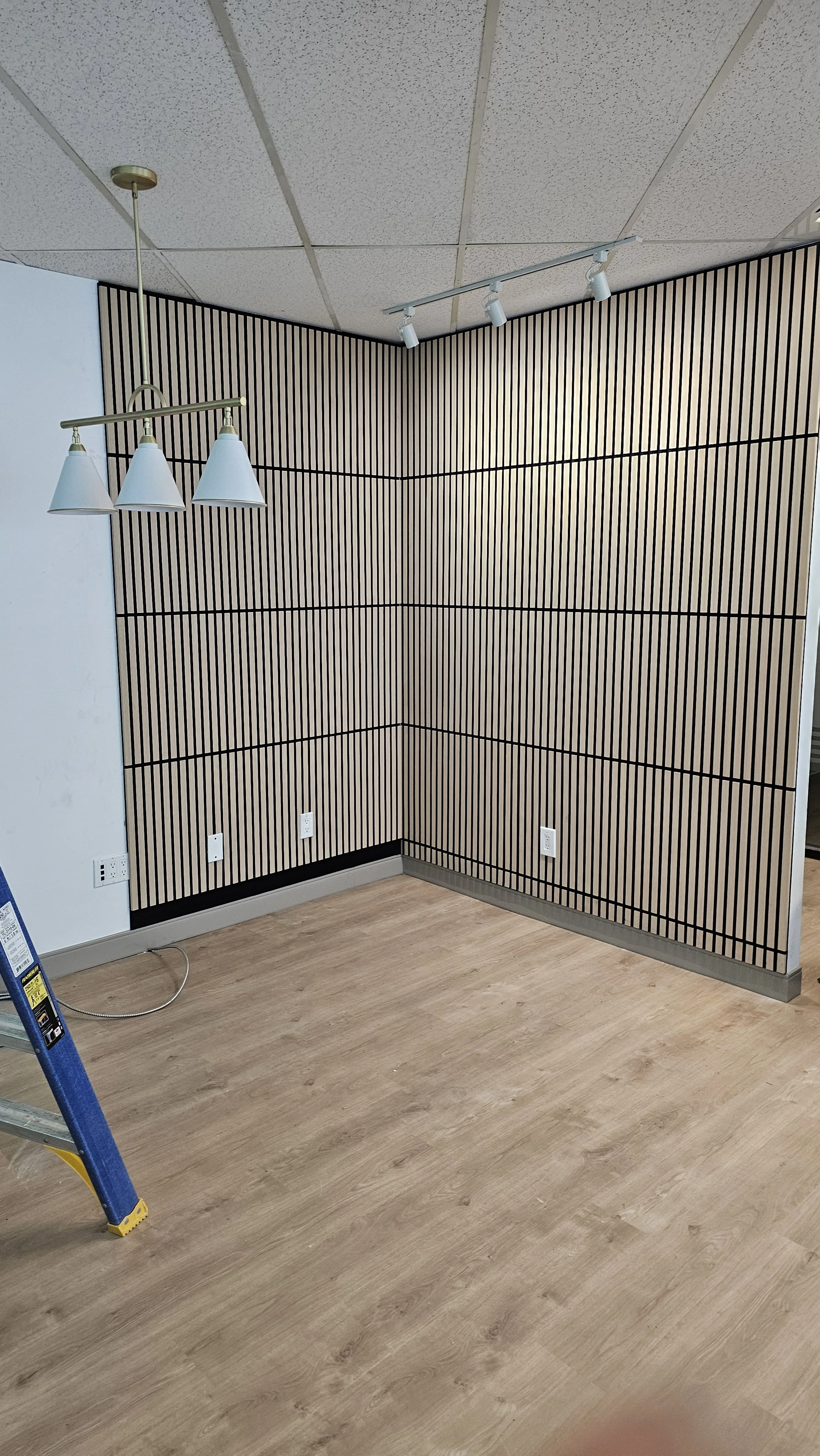 As part of this commercial office renovation, we installed custom wall paneling behind the receptionist desk, creating a sleek and professional feature wall that immediately elevates the workspace. The panels add texture, depth, and a modern design e
