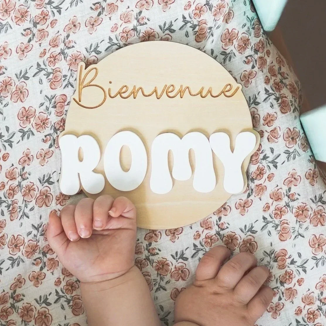 Carte de naissance personnalisée en bois et acrylique « Bienvenue Romy », tenue par un bébé