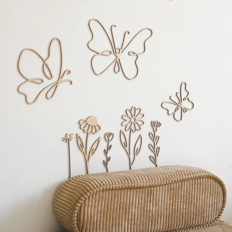 Fleurs et papillons en bois au mur d'une chambre de bébé