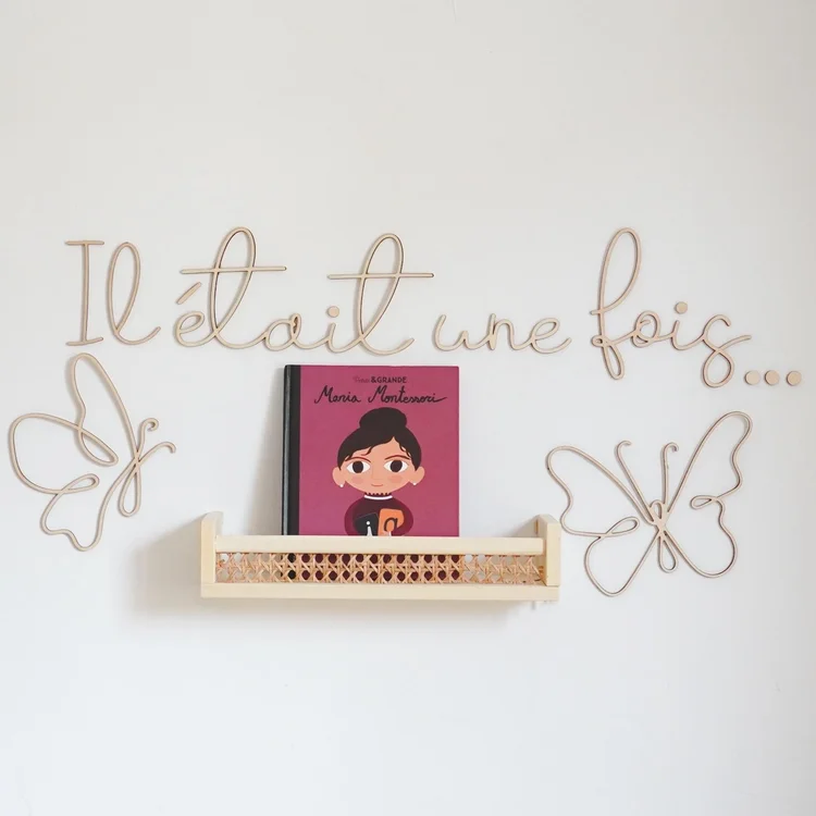 Décoration murale « Il était une fois… » en lettres de bois et deux grands papillons ajourés au-dessus d'une étagère