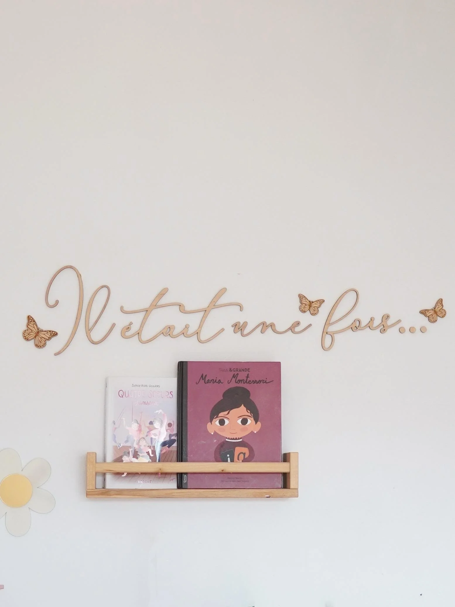 Décoration murale en bois « Il était une fois » avec papillons au-dessus d’une étagère à livres
