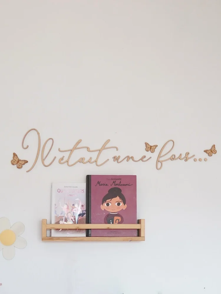 Décoration murale « Il était une fois… » en lettres de bois attachées avec papillons, au-dessus d'une étagère à livres