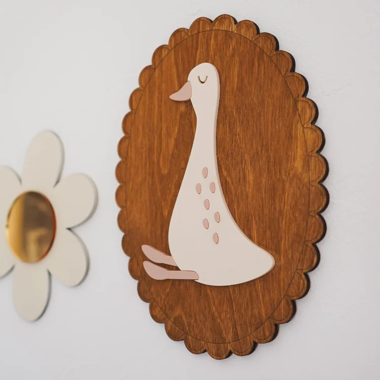 Décoration murale oie crème à pois roses sur médaillon ovale en bois brun à bord festonné