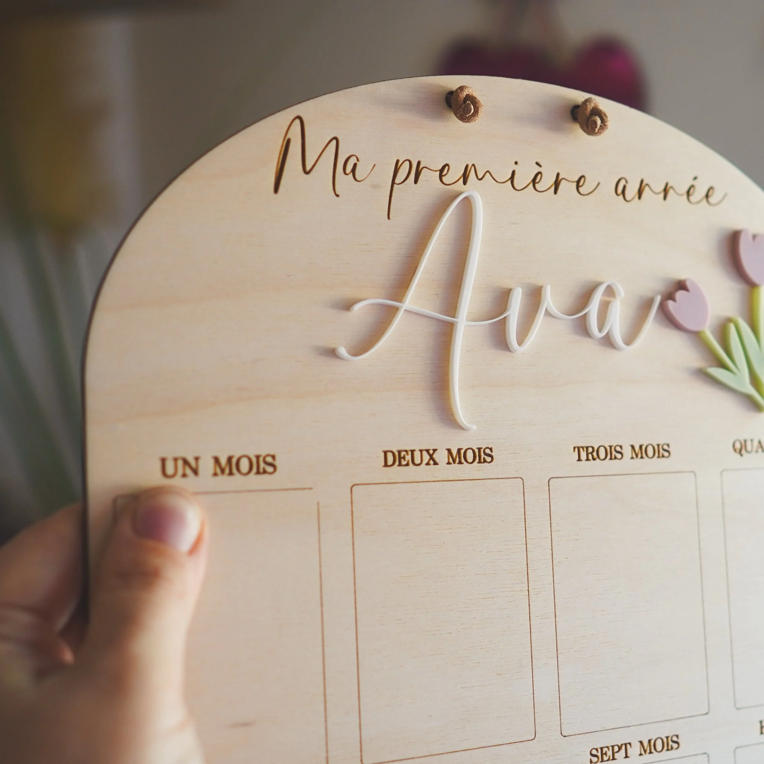 Panneau à tulipes au prénom « Ava » tenu en main, cases des premiers mois visibles