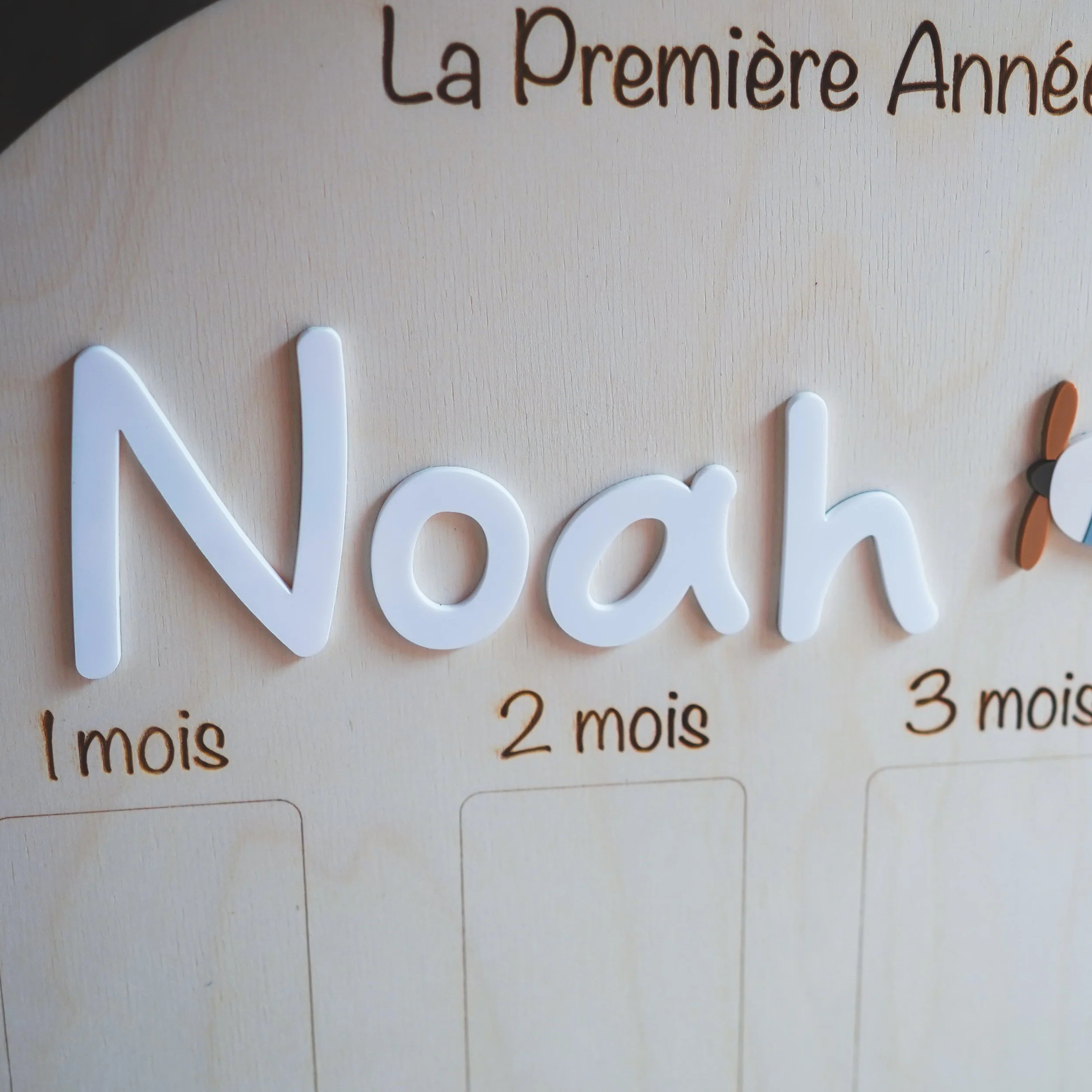 Prénom Noah en lettres blanches en relief sur le panneau photo première année en bois