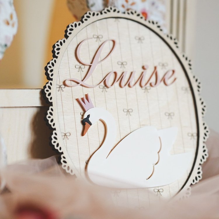 Décoration murale cygne personnalisée avec prénom sur une plaque ovale dentelée